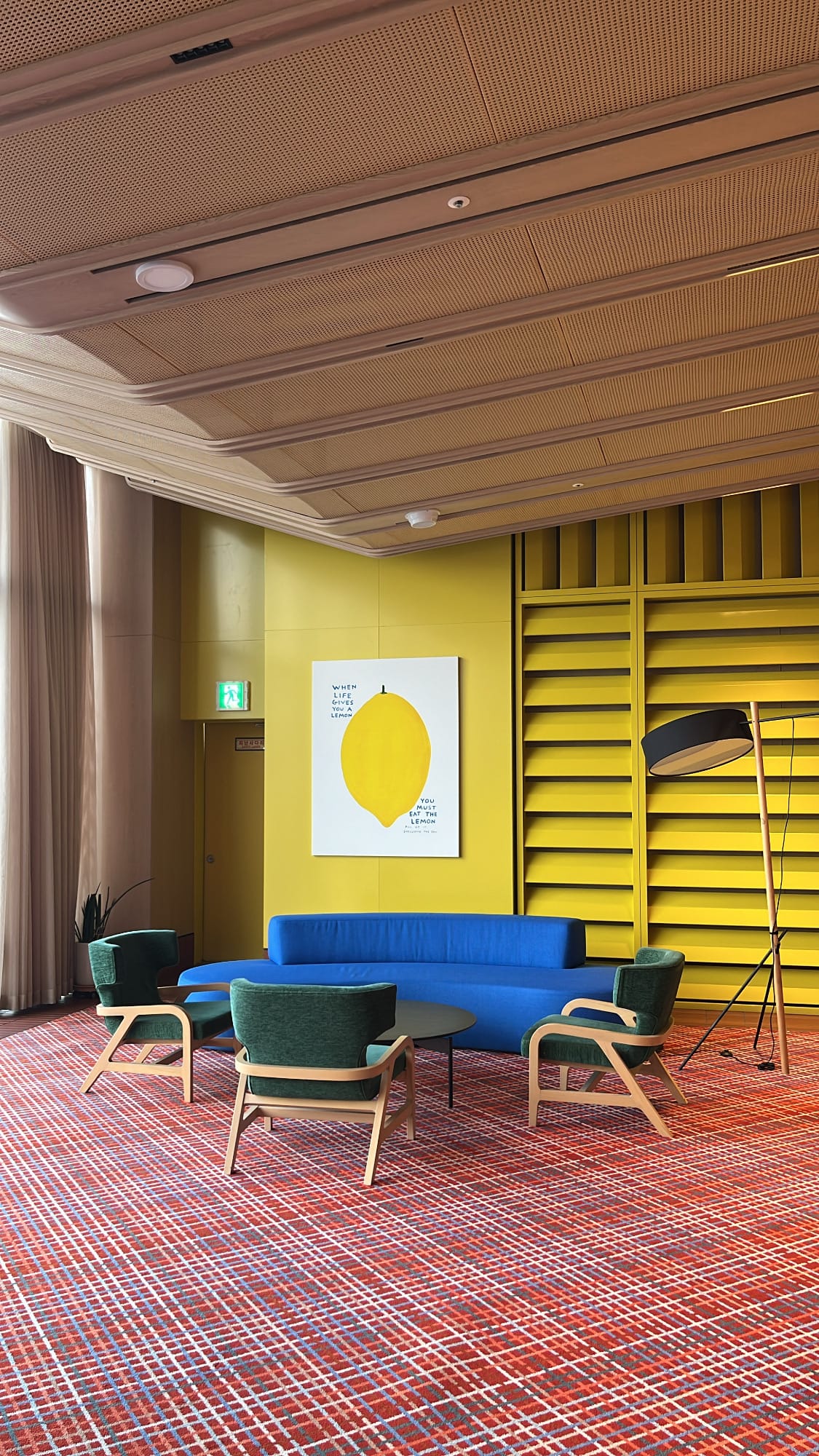 Cozy sofa seating against a vibrant yellow wall at The Coolest Hotel
