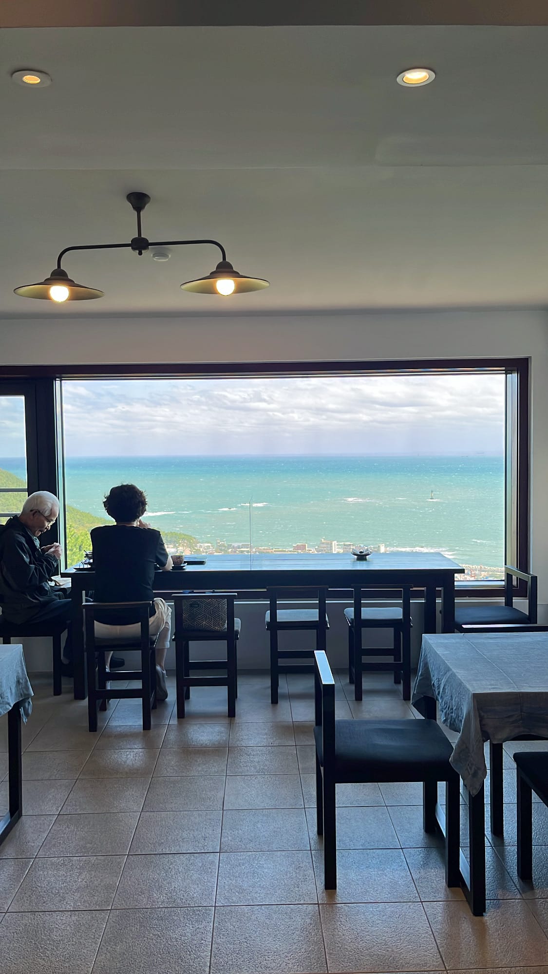 Chair and table seating arrangement facing the ocean-view window