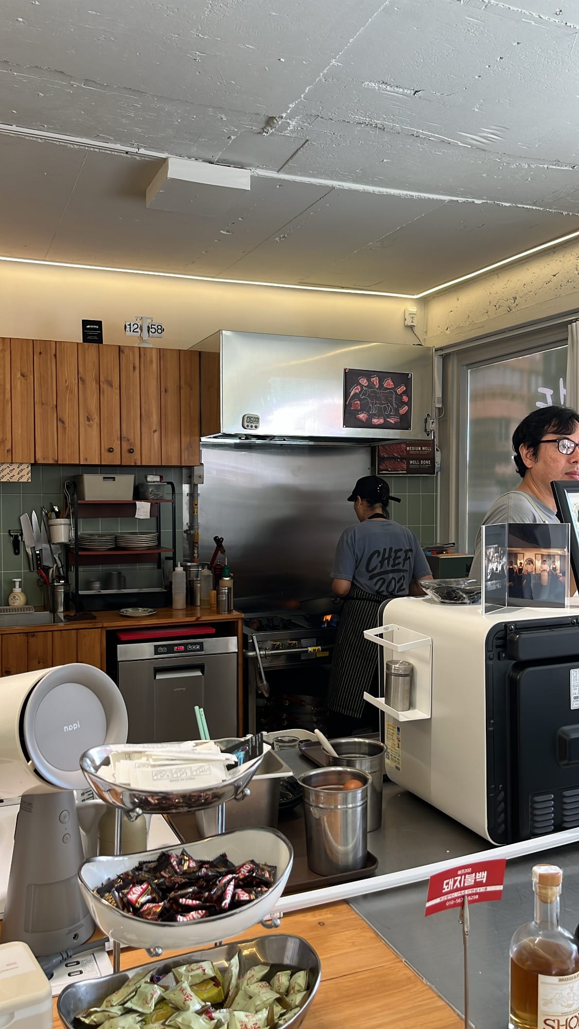 Chef grilling marinated pork in the open kitchen at Chef202 Busan