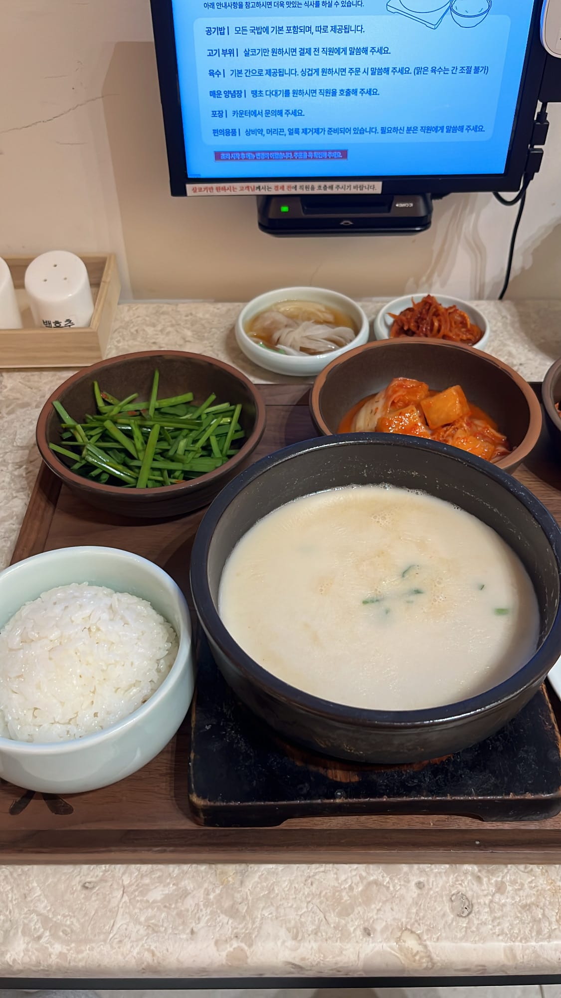 Close-up of rich milky-white boiling pork bone broth bowl at Geodae Dwaeji Gukbap Busan