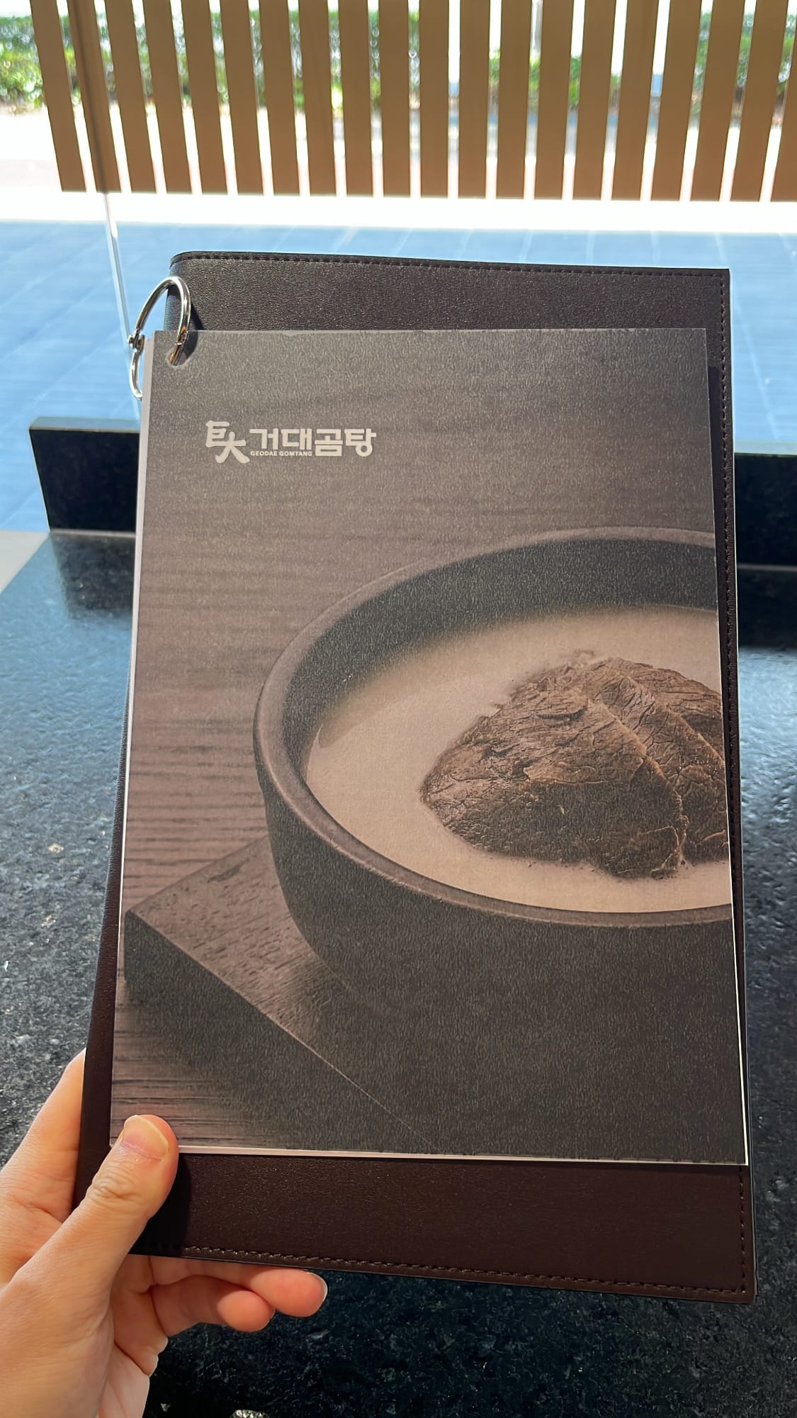 Leather-bound English menu book cover of Geodae Gomtang Busan
