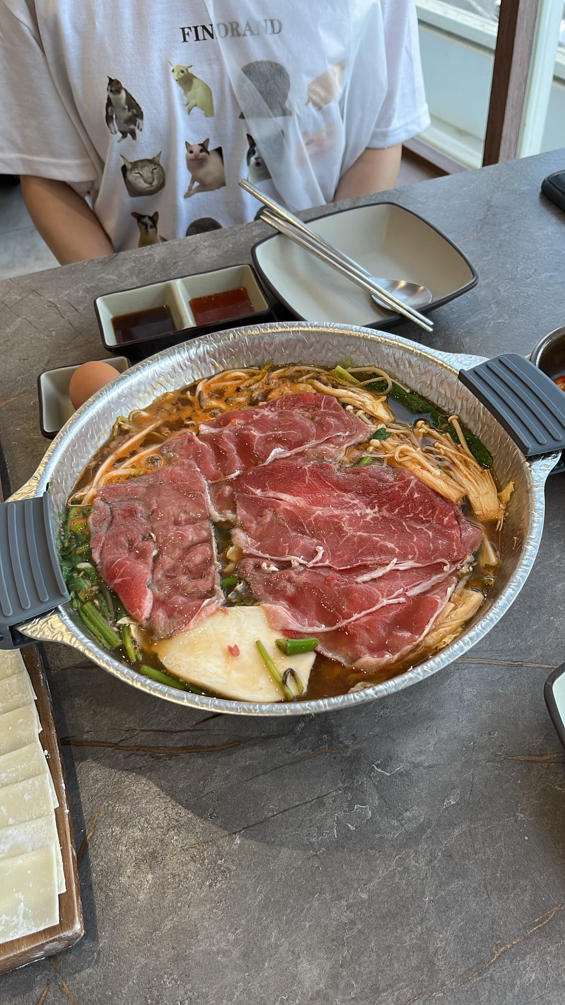 Simmering shabu-shabu pot with sliced beef cooking in rich broth
