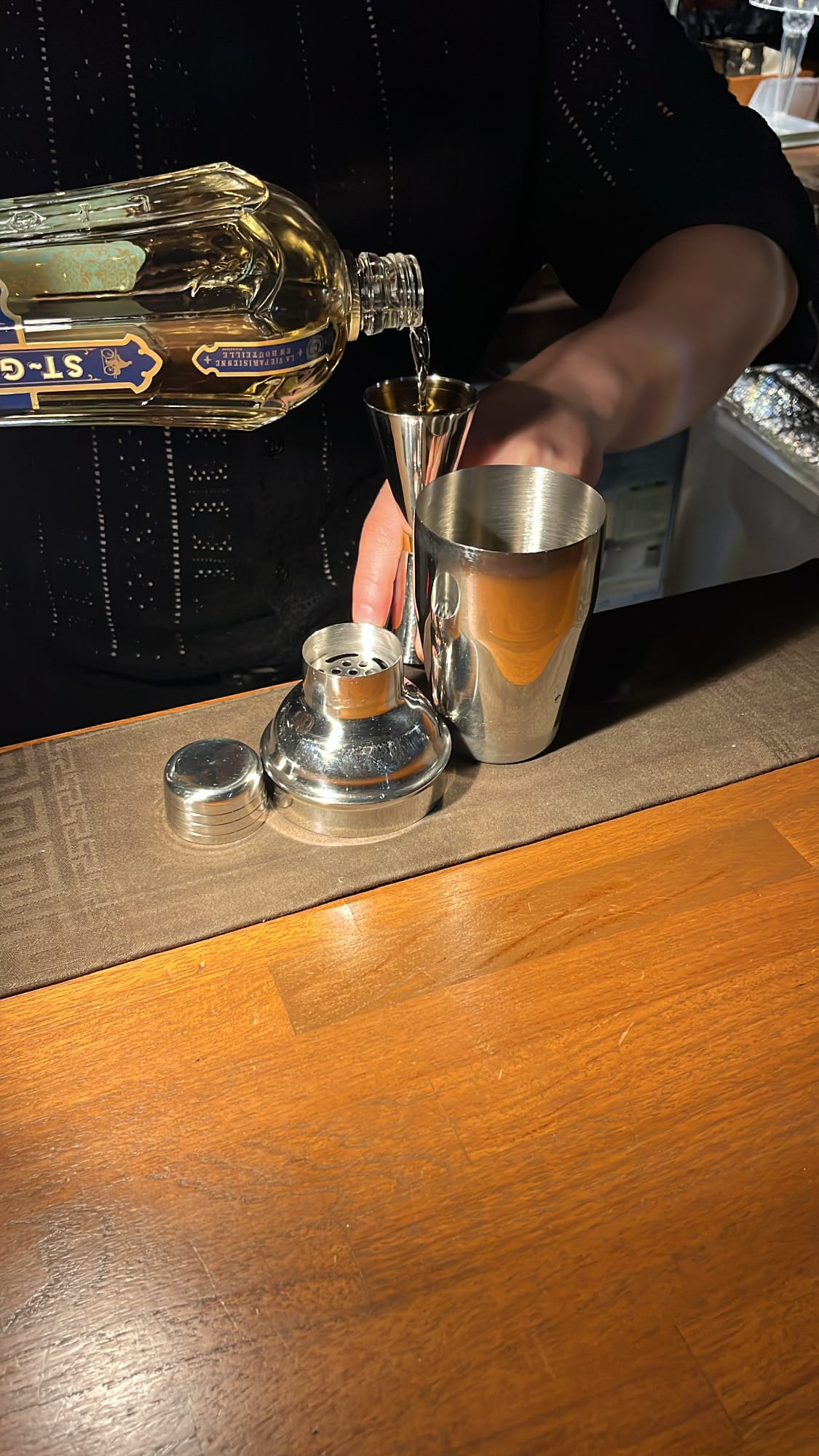 Bartender pouring St-Germain elderflower liqueur into jigger