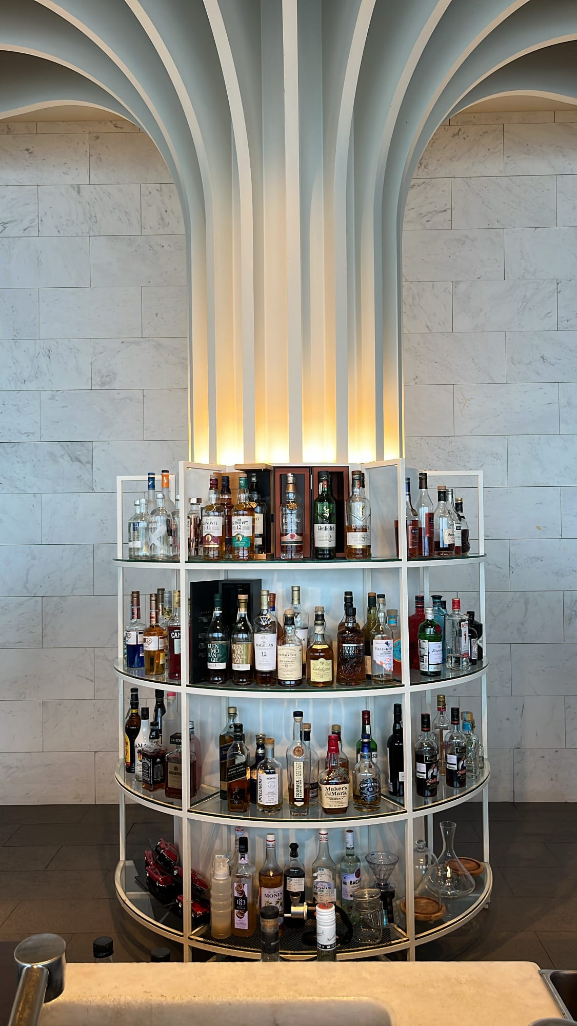 Modern back-lit liquor display and cocktail bar station at McQueen's Grill and Bar