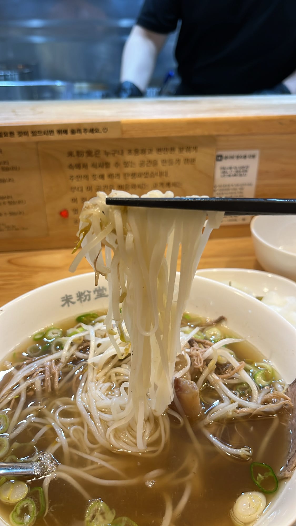 Lifting tender rice noodles from the beef broth bowl at Mibundang Centum City