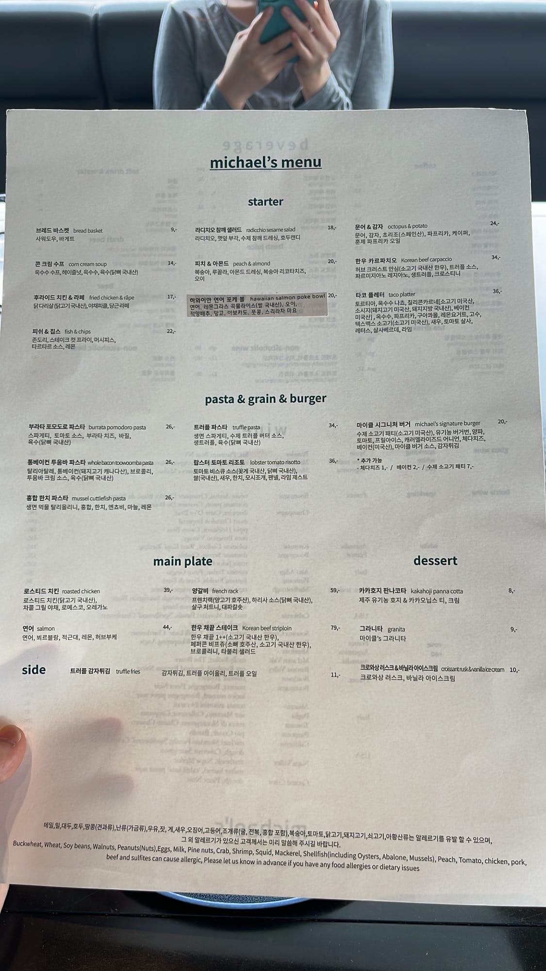 Hand holding Michael's course menu card at the dining table