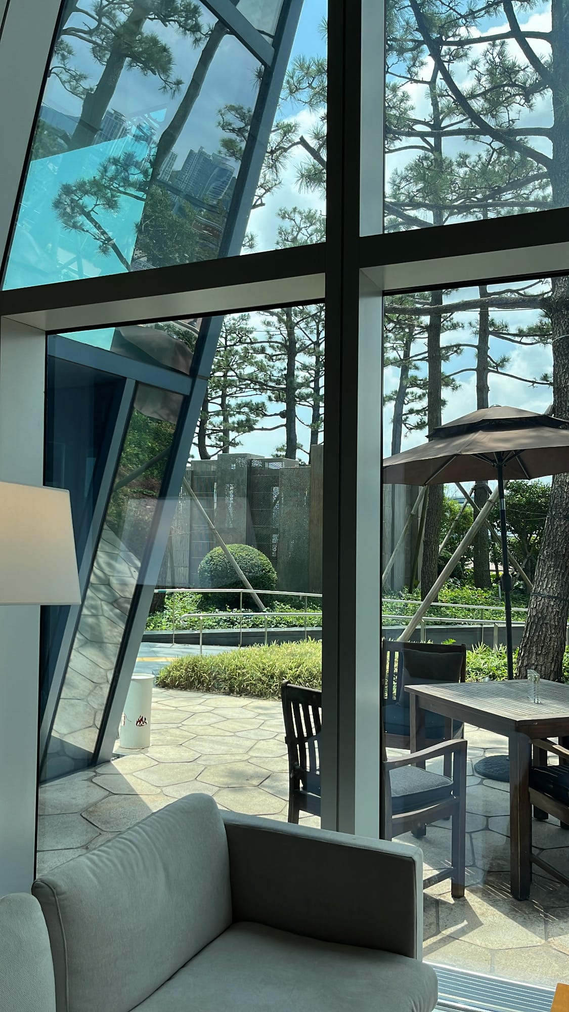 ลานสวนที่อาบแสงแดดและเทอเรสกลางแจ้งพร้อมร่มกันแดดที่ Patisserie Park Hyatt Busan