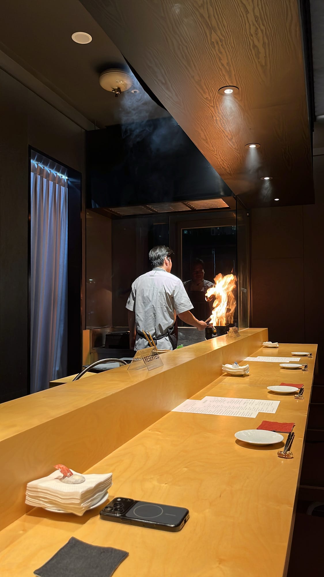 Chef straw-grilling bluefin tuna tataki with rising flames at Murasaki Busan