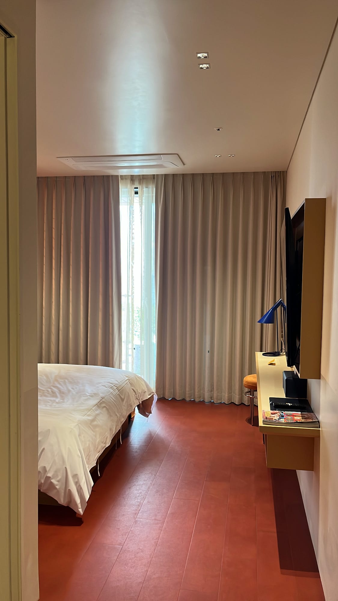 Bedroom entryway featuring reddish-brown flooring at The Coolest Hotel