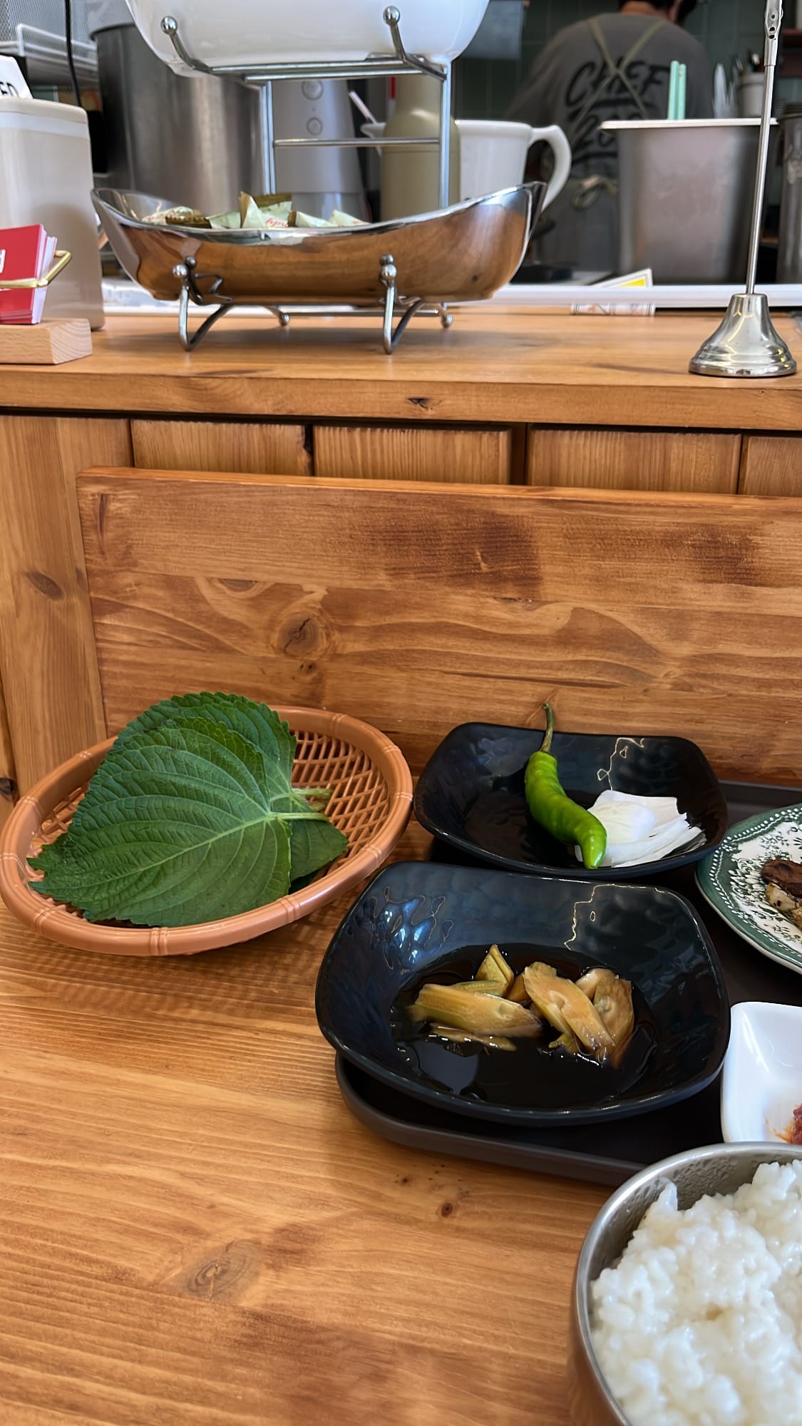 Fresh perilla leaves and pickled vegetables served with bulbaek at Chef202 Busan