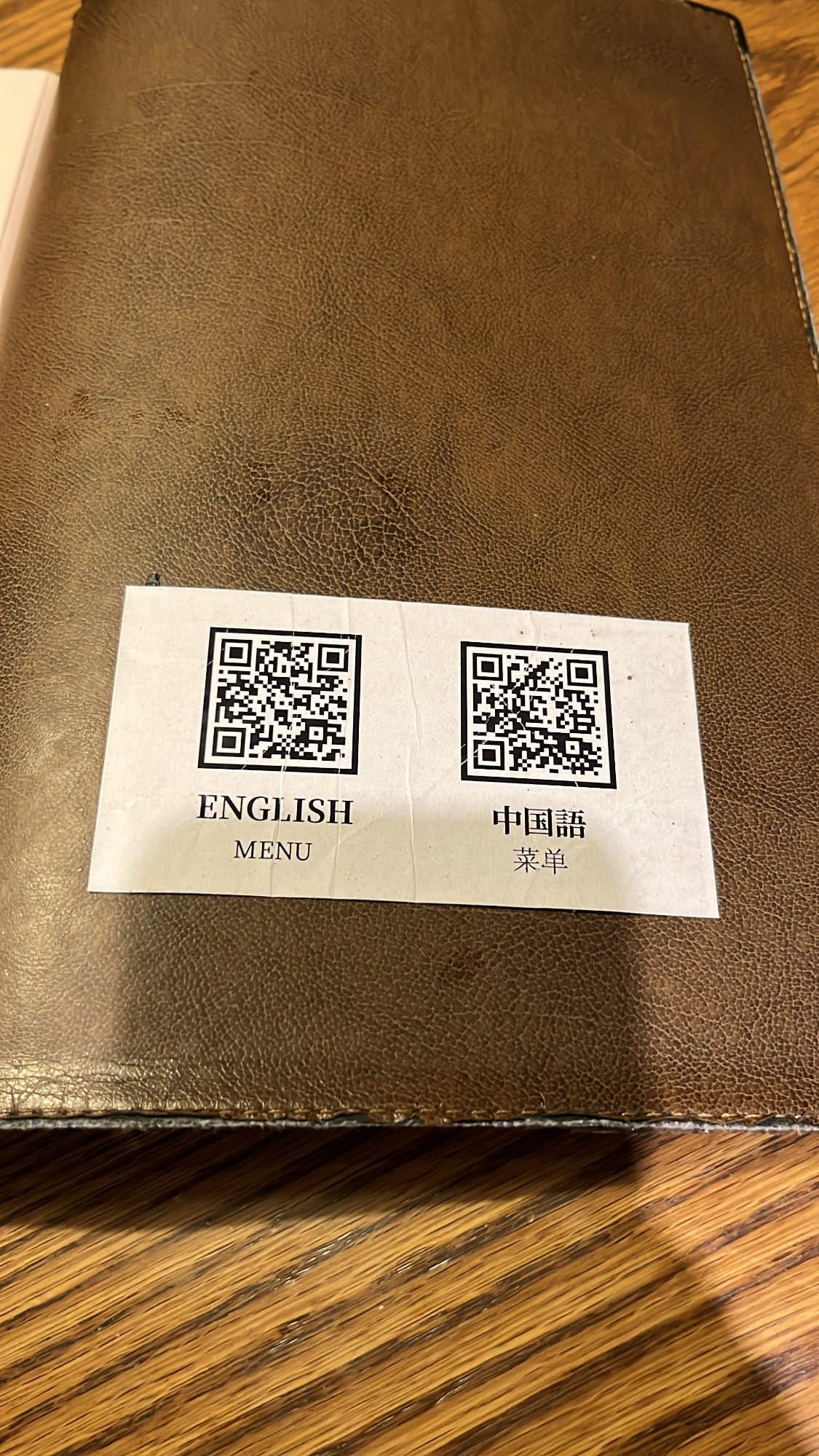 ヘモクのテーブルに貼られた、英語と中国語の多言語対応QRコード付きデジタルメニューステッカー