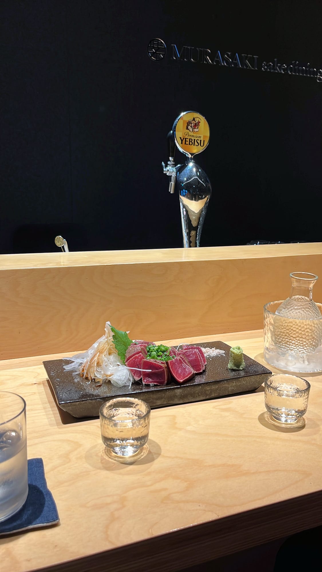 Plated straw-grilled maguro tataki served with sake at Murasaki Busan