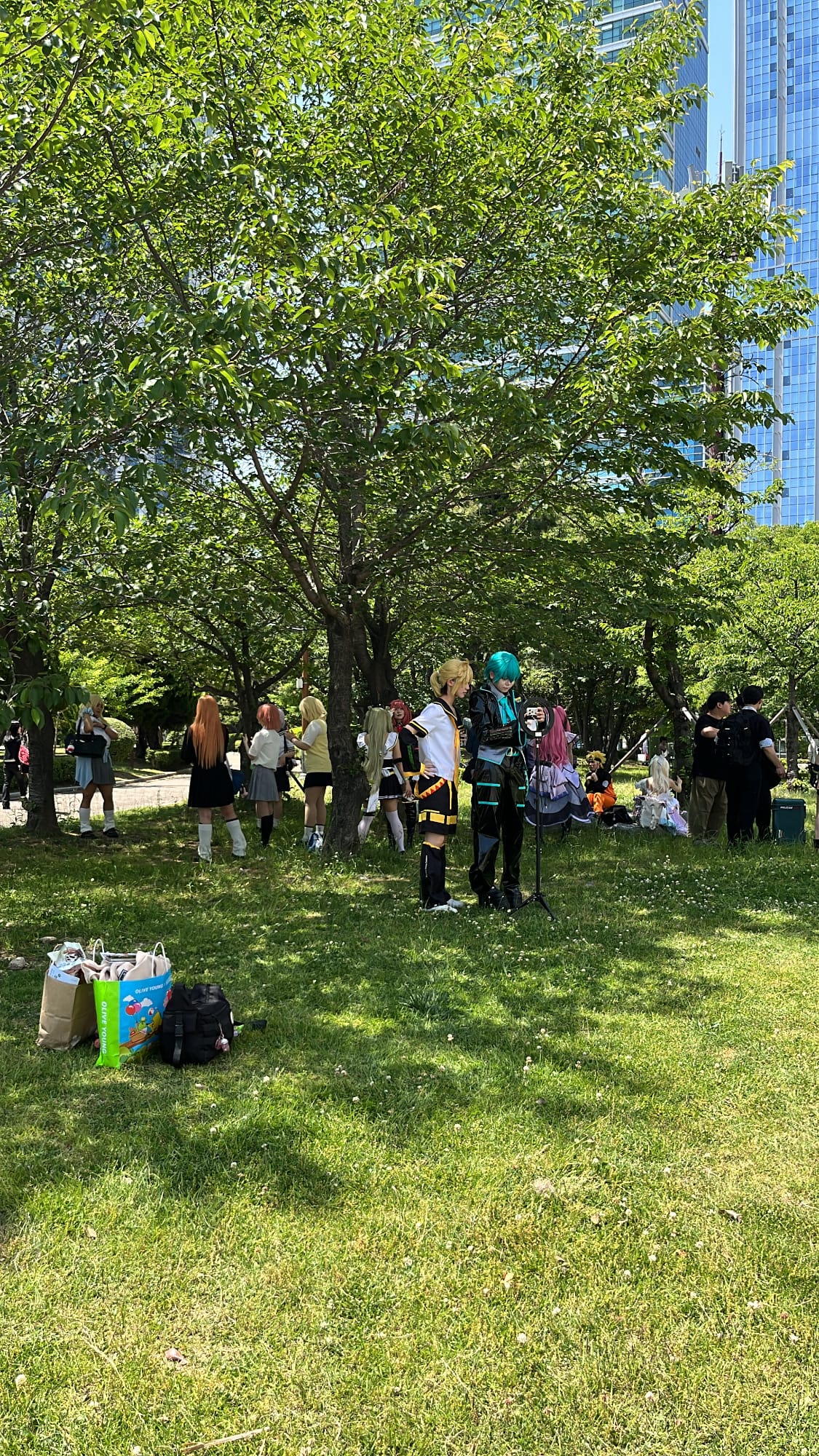 Anime cosplayers resting in the shade outside BEXCO