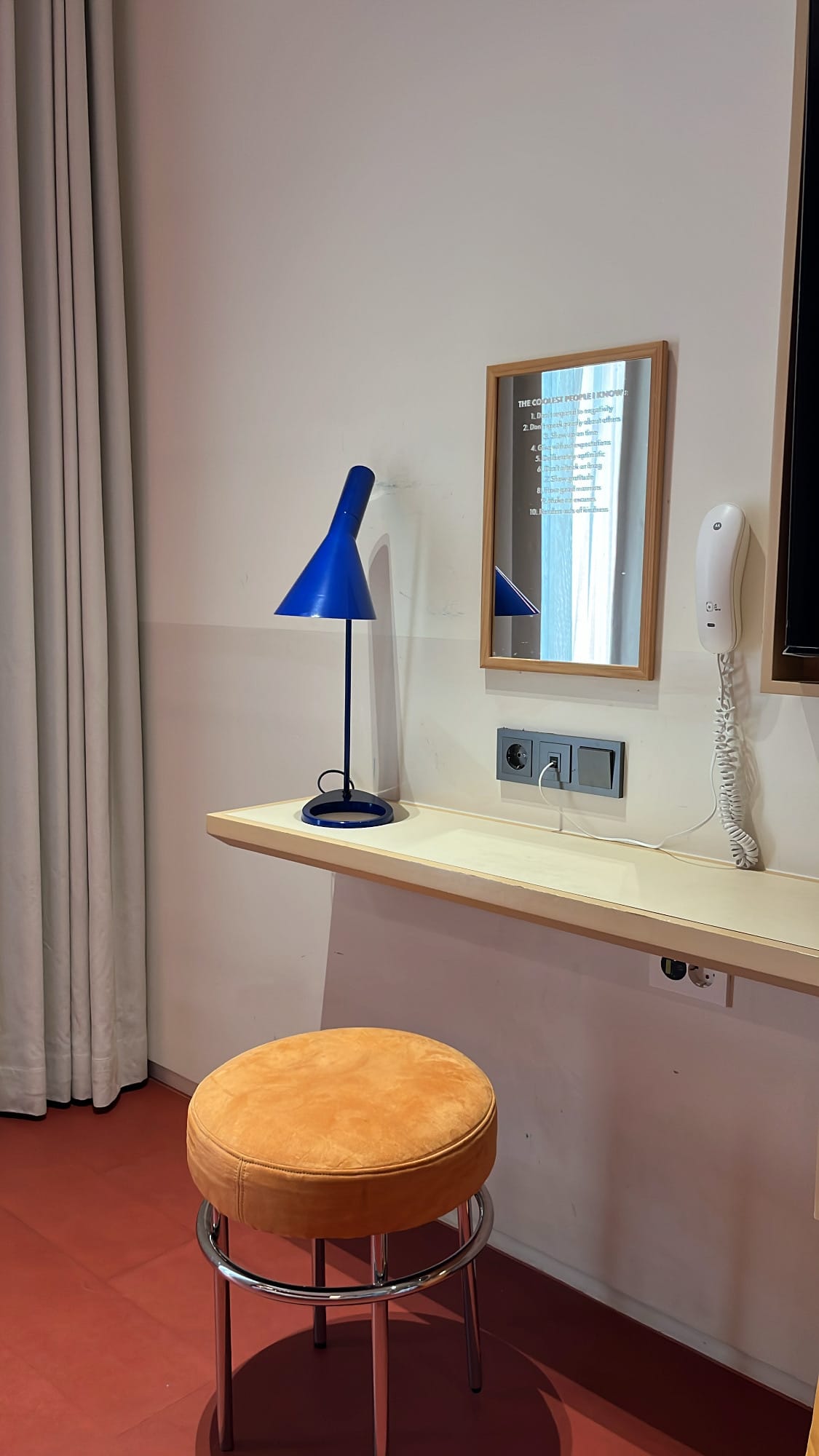 Minimalist vanity desk with cobalt blue lamp at The Coolest Hotel