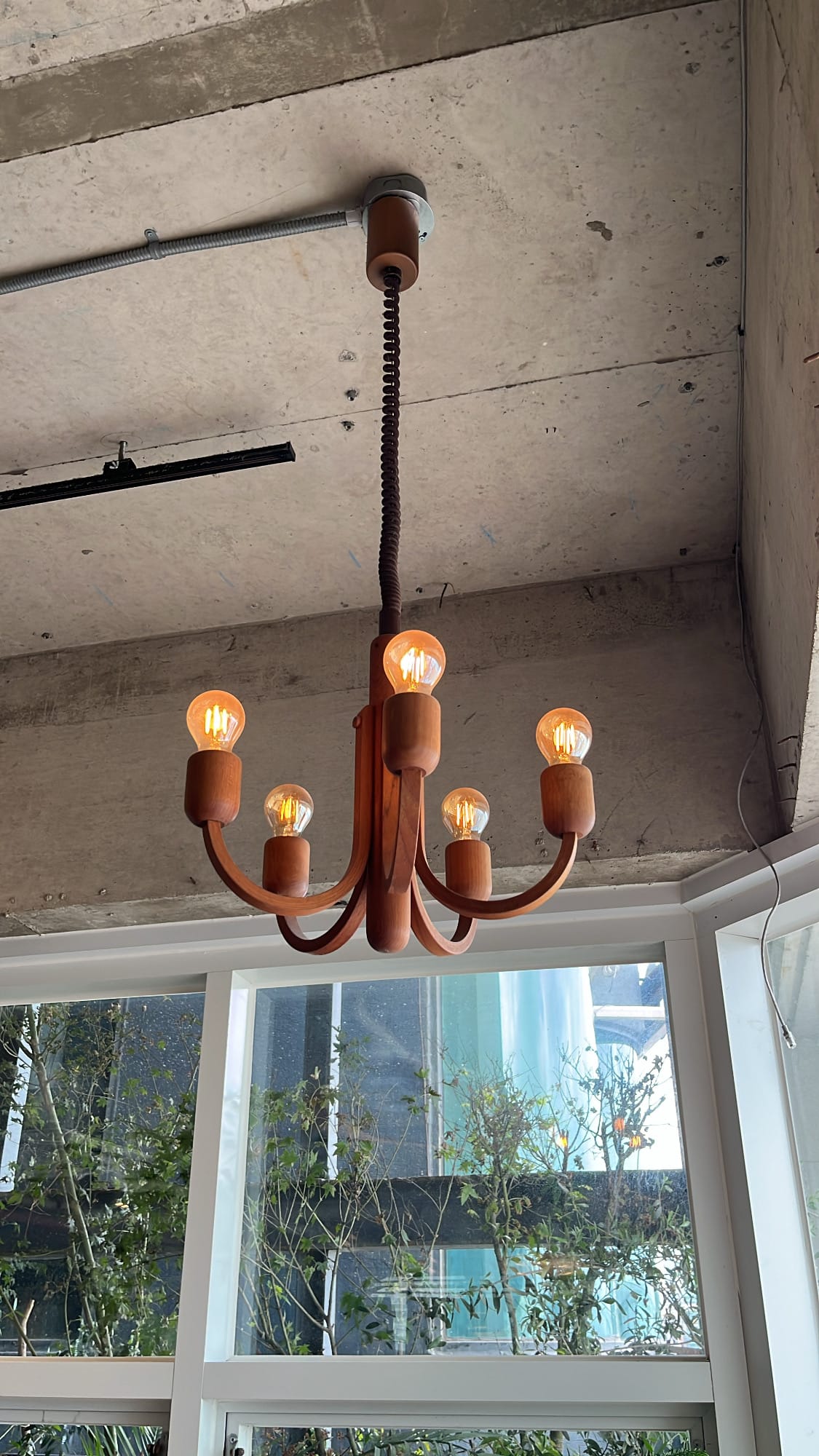 โคมระย้าไม้แบบคลาสสิกที่ช่วยเน้นความสูงของเพดานที่ Working Holiday Brunch Cafe Busan