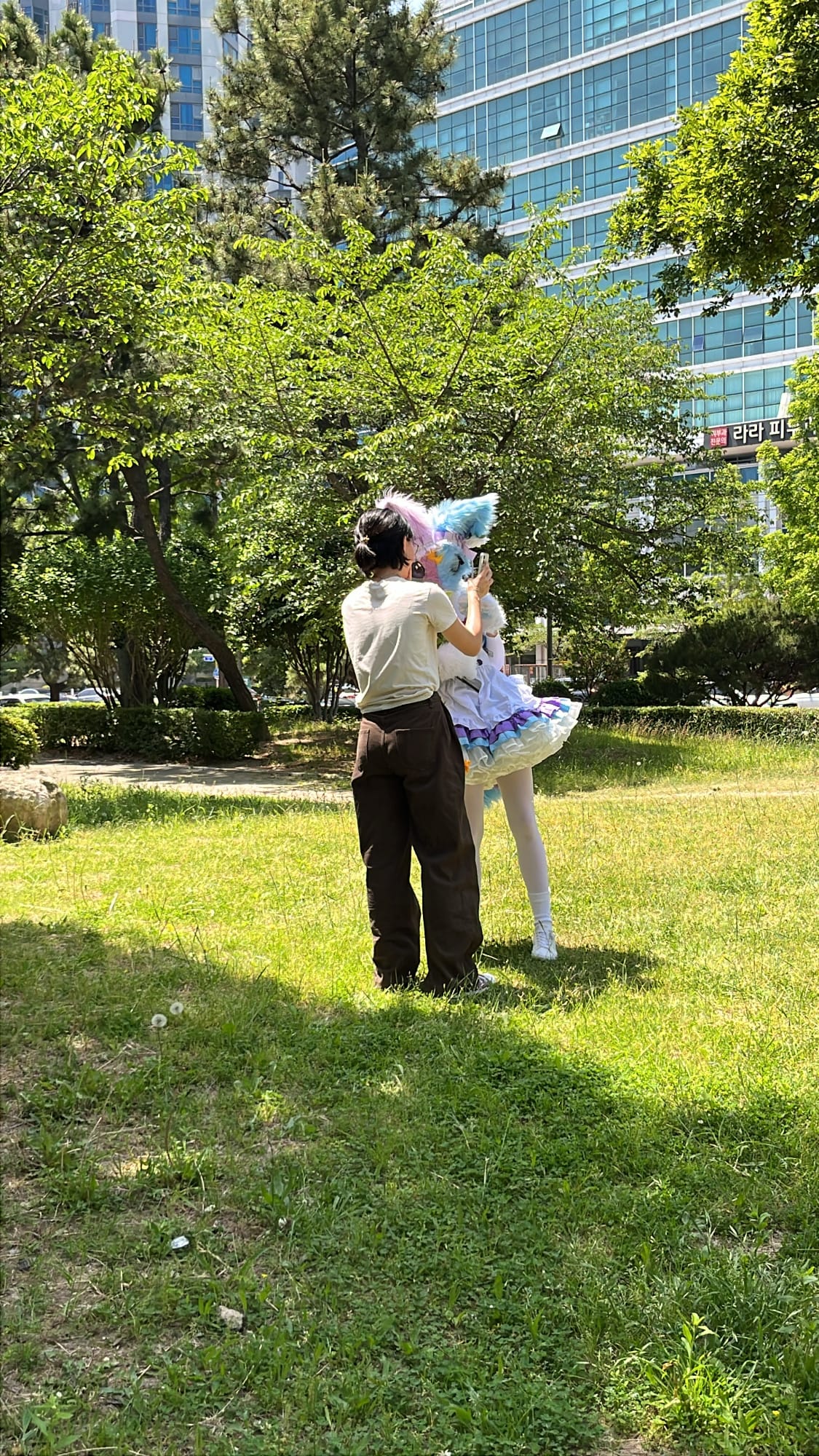 Photographer directing fursuit cosplayer pose outside BEXCO