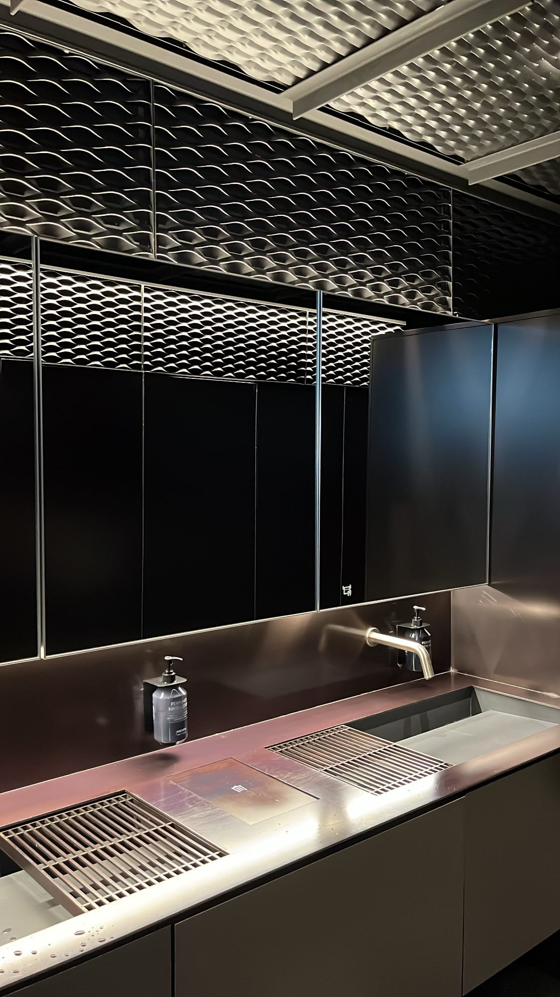 Minimalist dark metallic restroom washbasin at Michael's Urban Farm Table