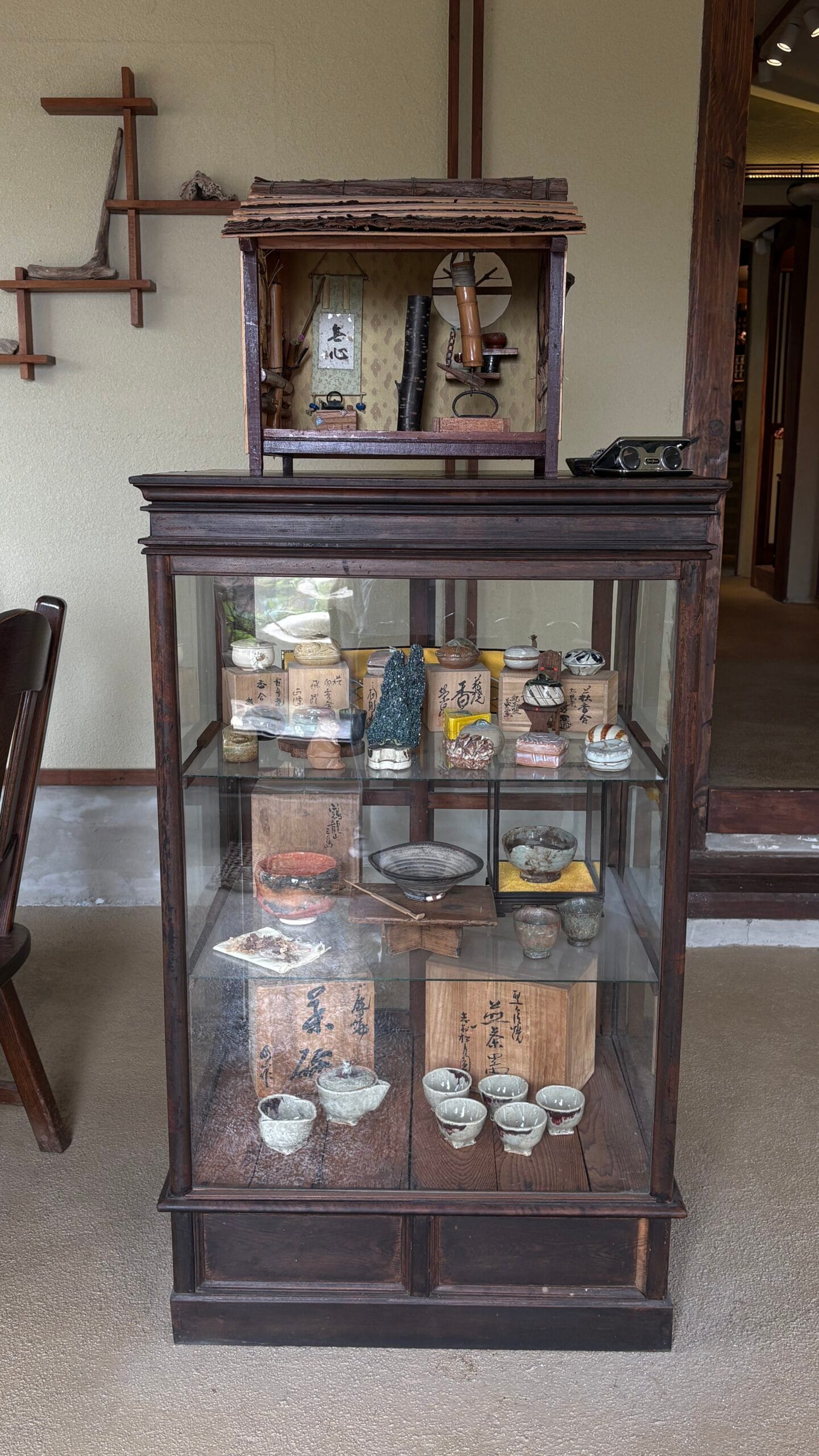Antique glass display cabinet filled with tea bowls and ceramics at Simmian Busan