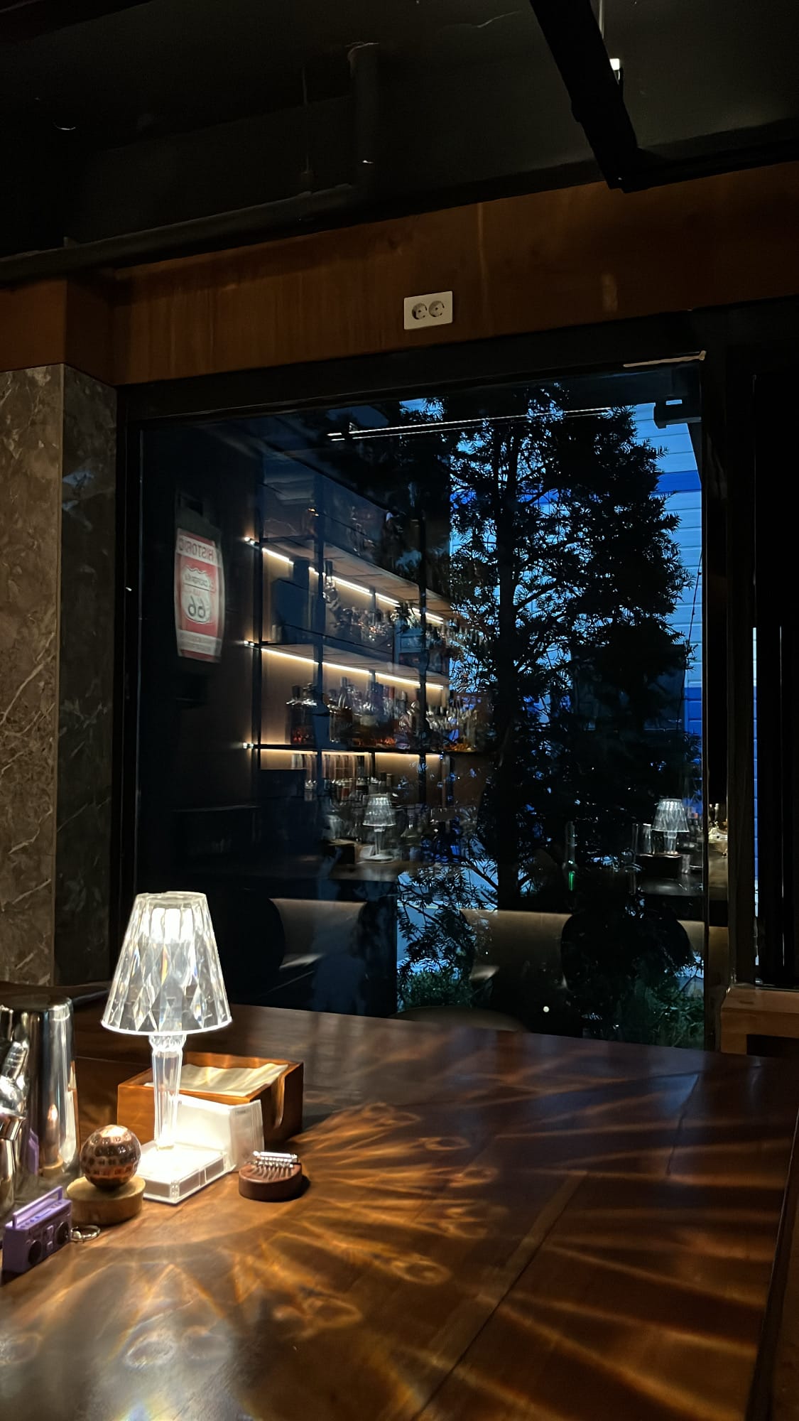 Countertop crystal lamp reflecting lush outdoor greenery at Bar Railside