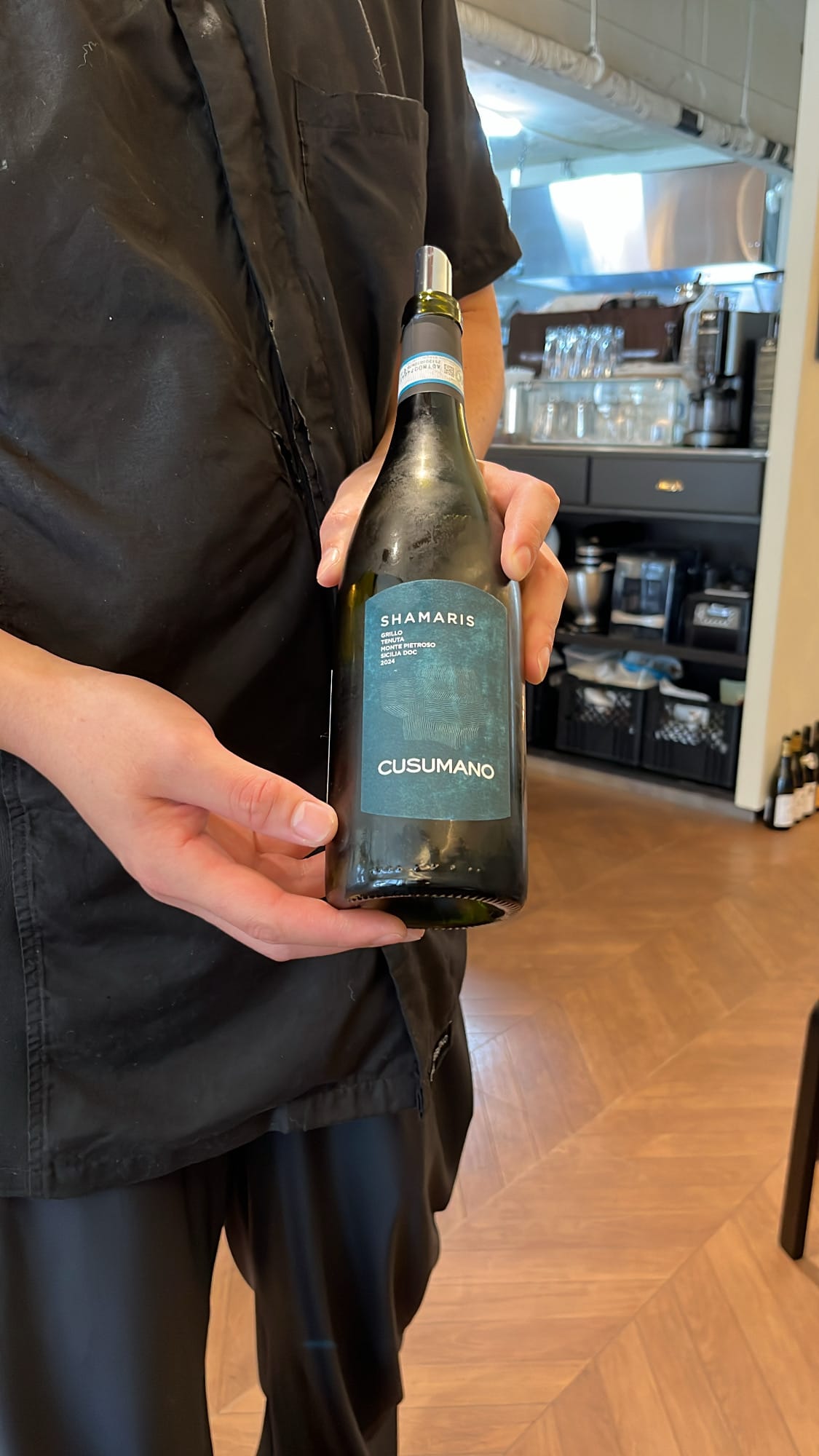 Danicci chef presenting chilled bottle of Cusumano Shamaris Grillo wine