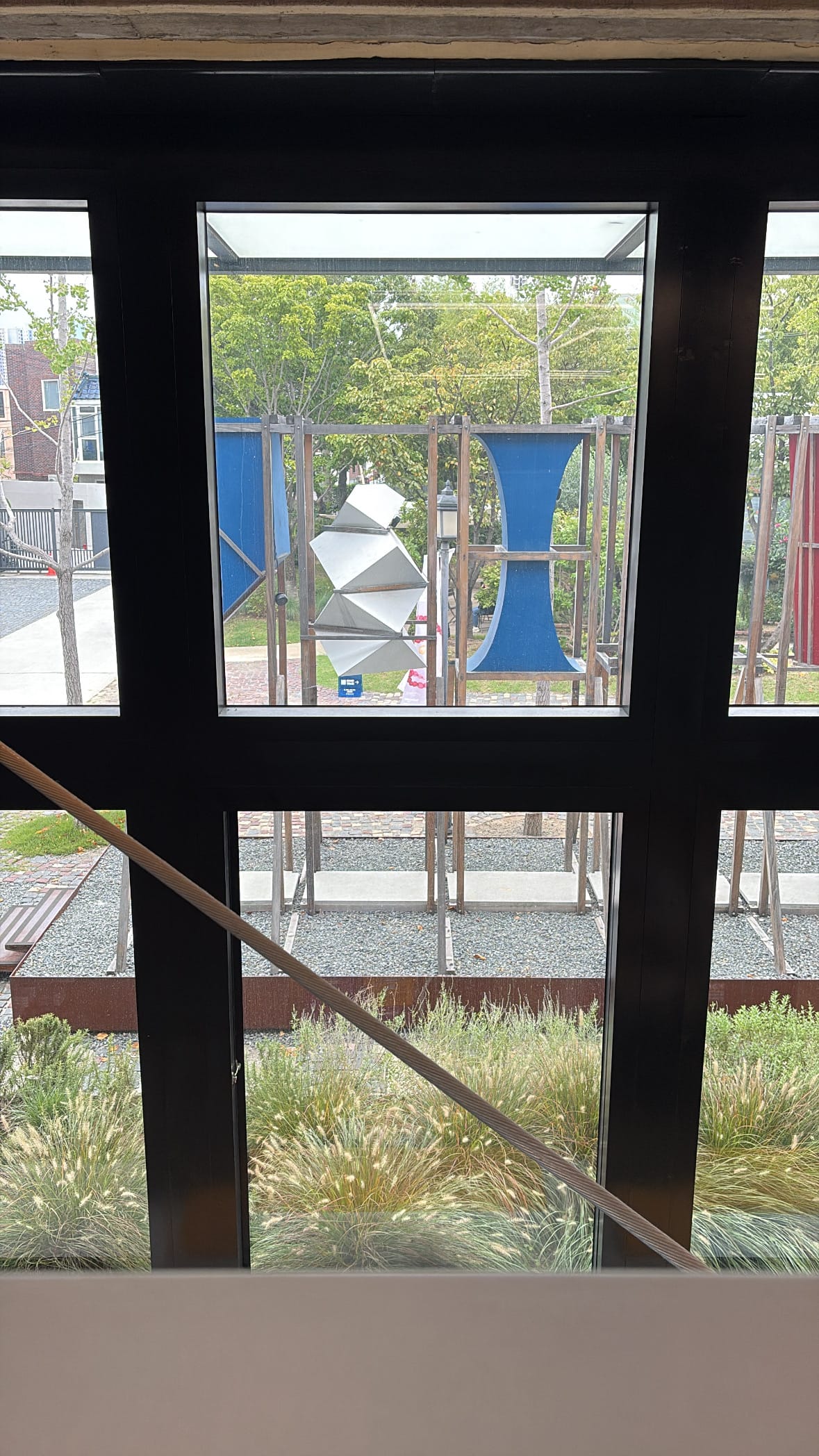 Black-framed glass window overlooking the courtyard garden at YES24 Busan