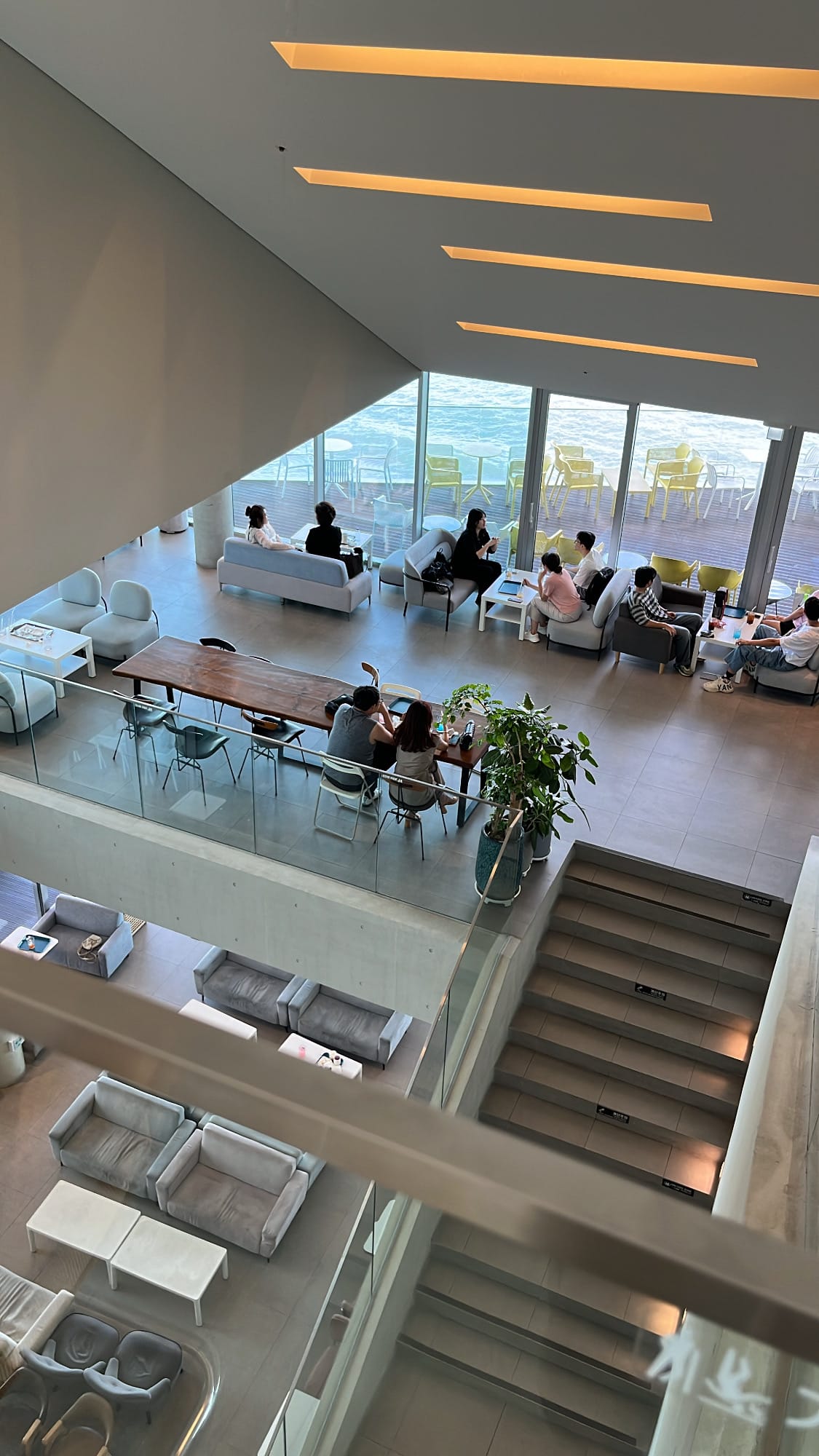 Overhead view looking down into the expansive open-concept seating atrium at Coralani Busan