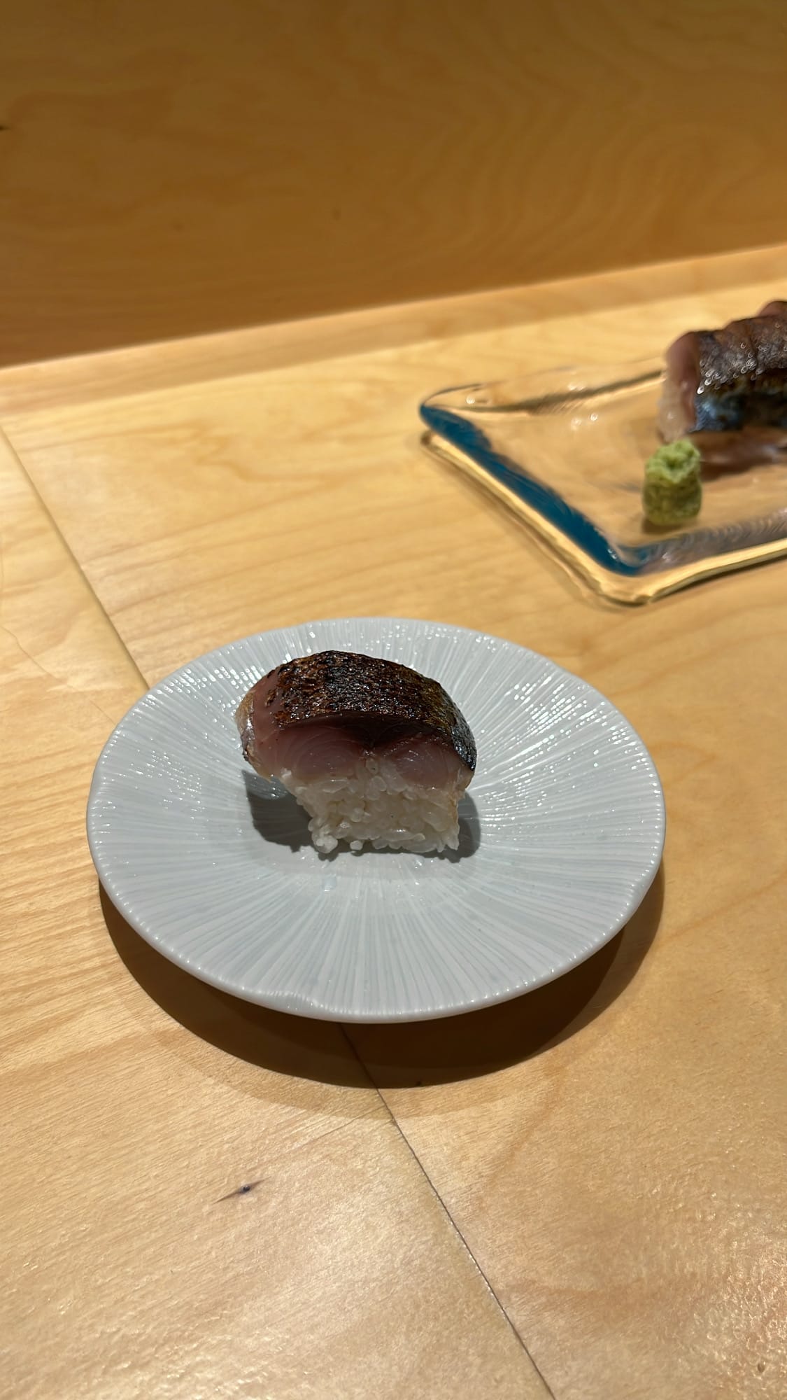 Close-up of a single piece of delicious saba bousushi on ceramic plate at Murasaki Busan