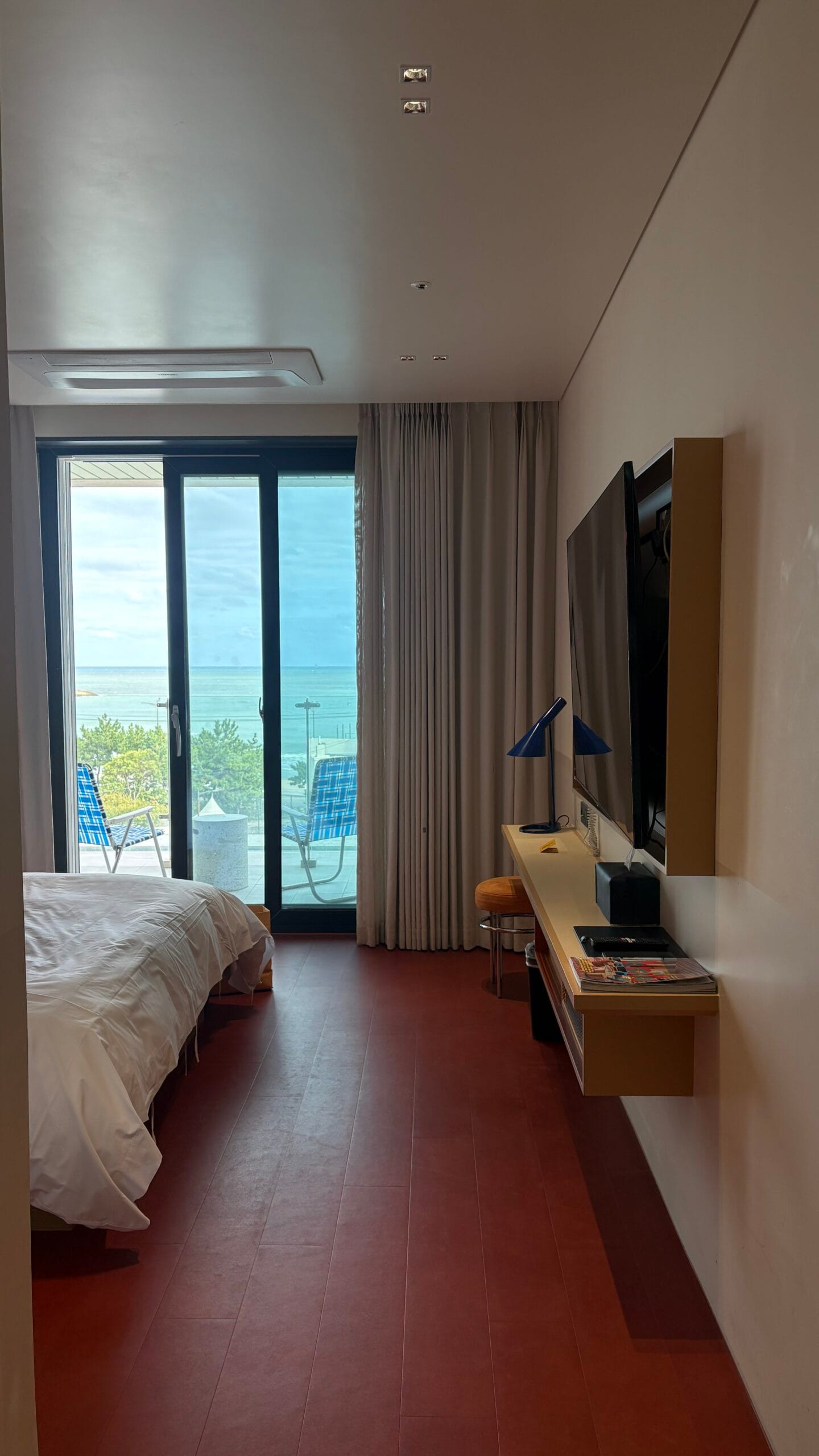 Terrace guestroom sliding door opening to Songjeong ocean view