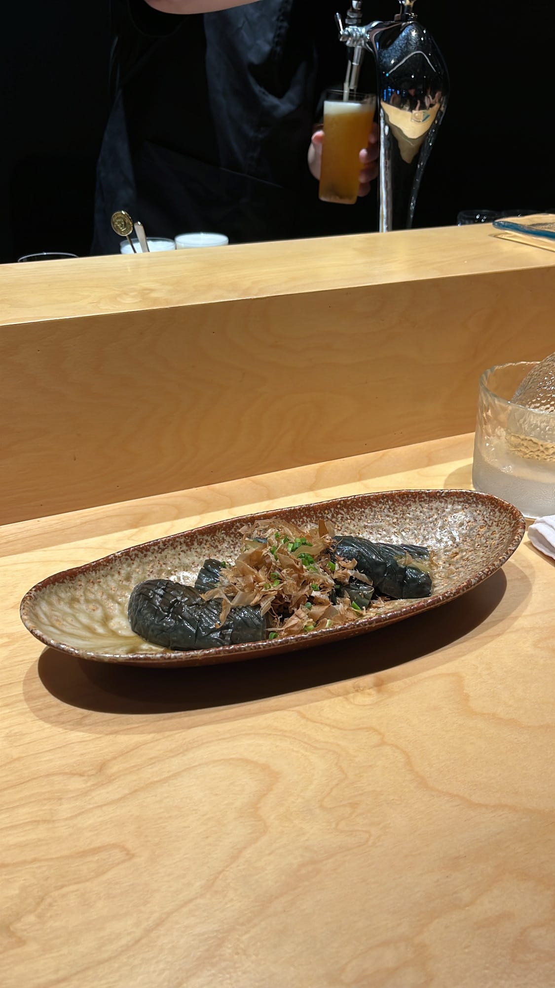Braised Japanese eggplant nasu nibitashi topped with bonito flakes at Murasaki Busan