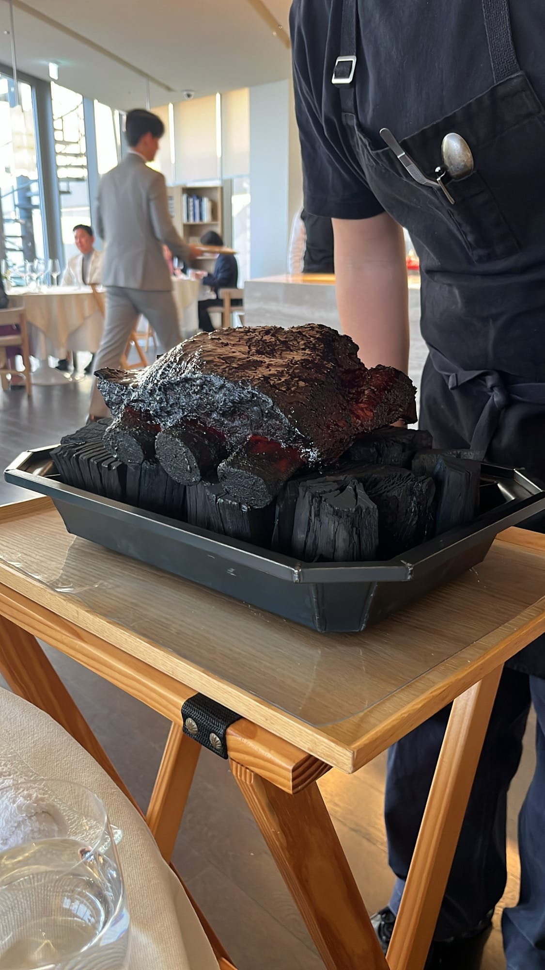 Whole smoked beef rib presented on charcoal by Imok