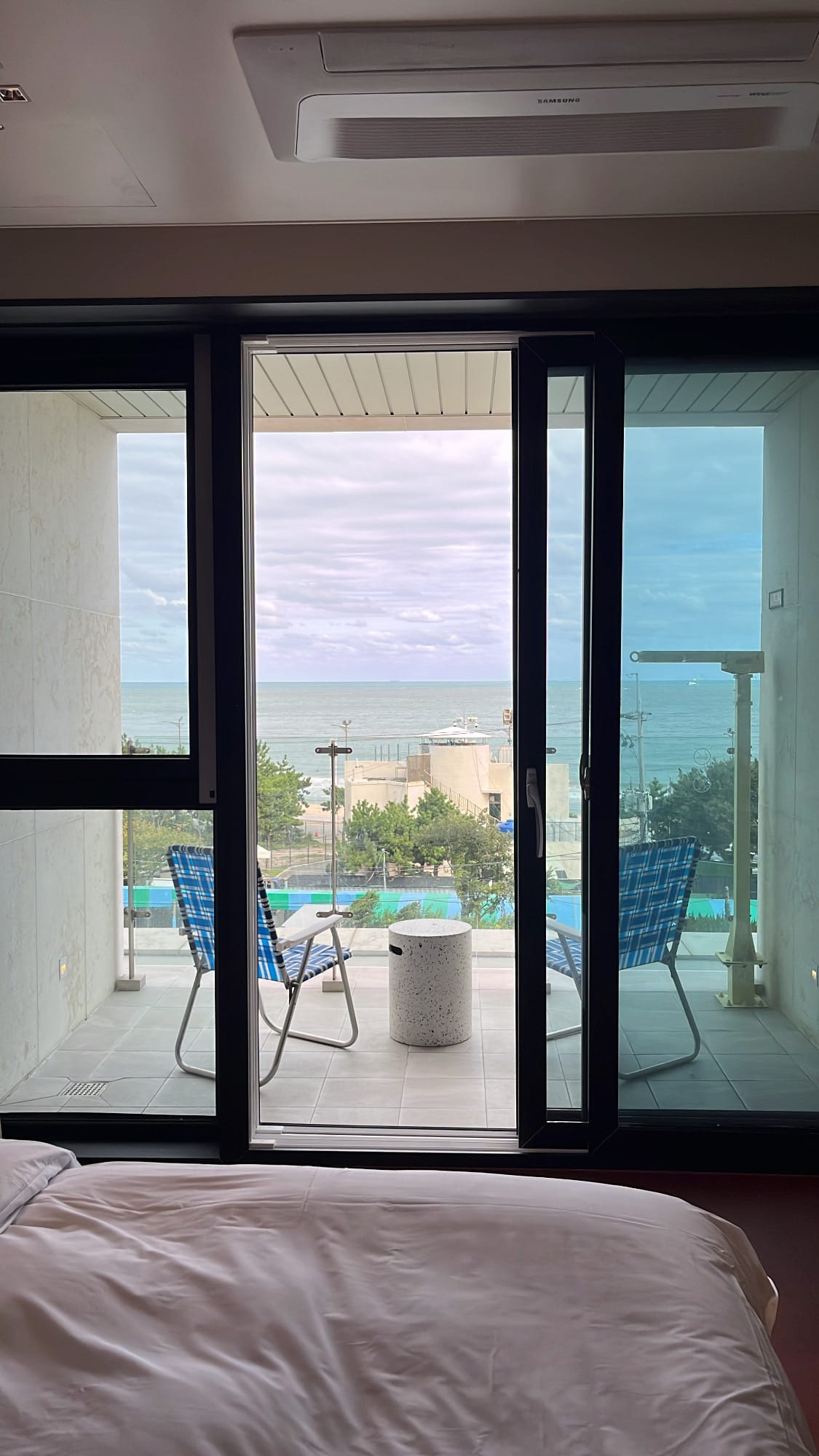 Bedroom window overlooking private terrace and blue horizon