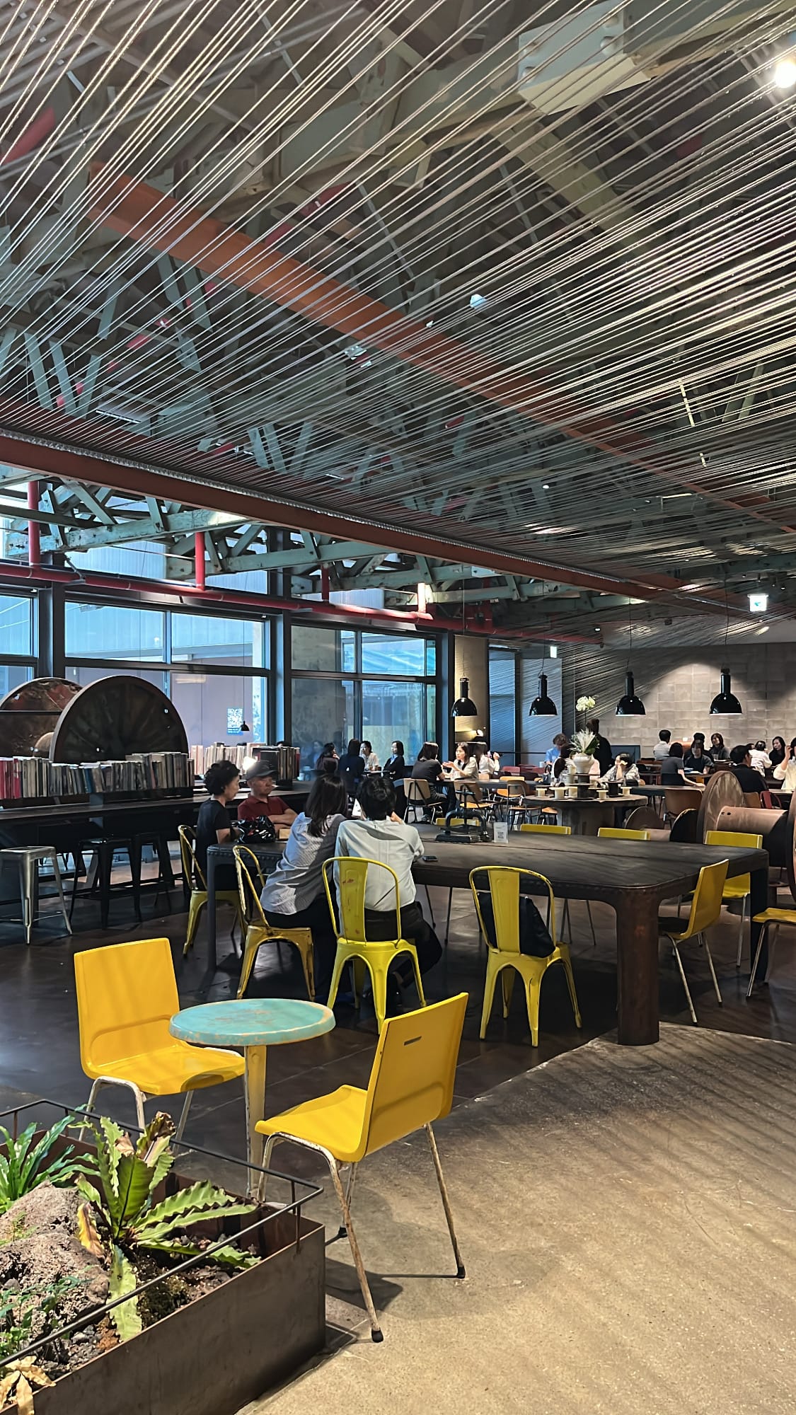 Spacious seating hall filled with guests beneath geometric wire ceiling