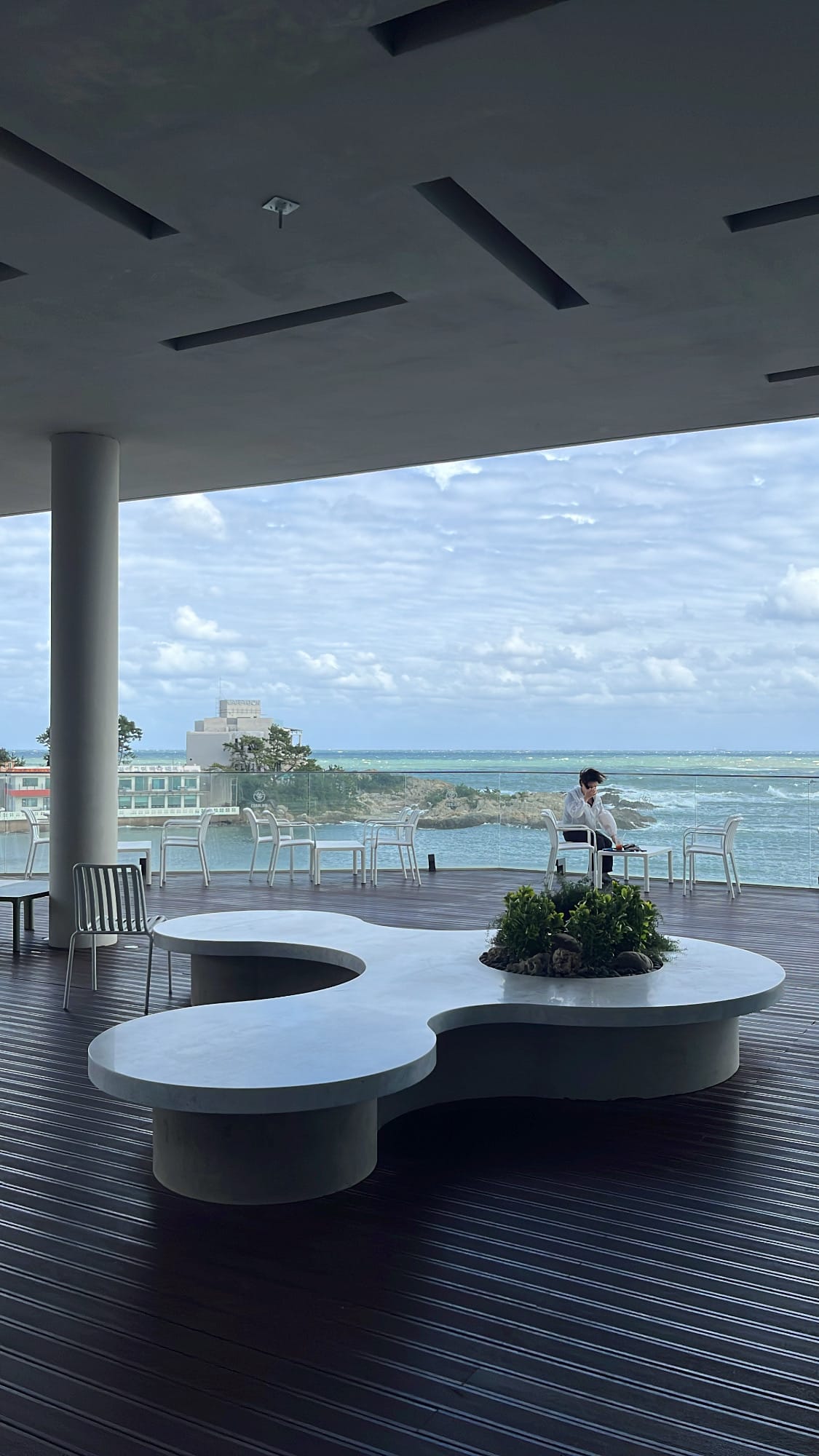 Covered first-floor outdoor terrace with sculptural stone benches at Coralani Busan