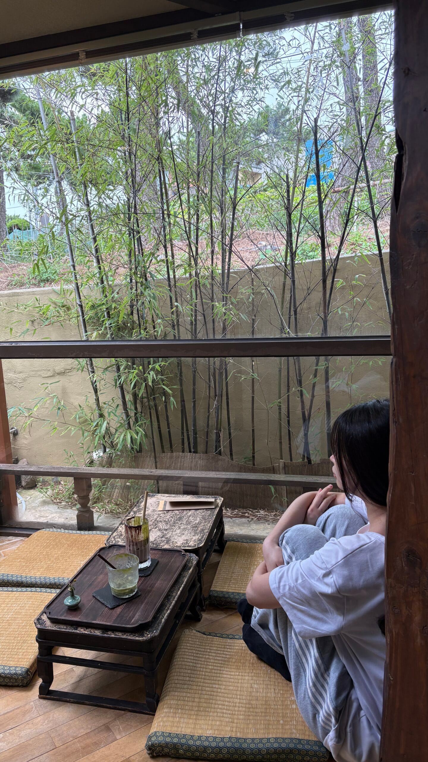 Guest relaxing on a comfortable tatami seat facing bamboo scenery at Simmian Busan