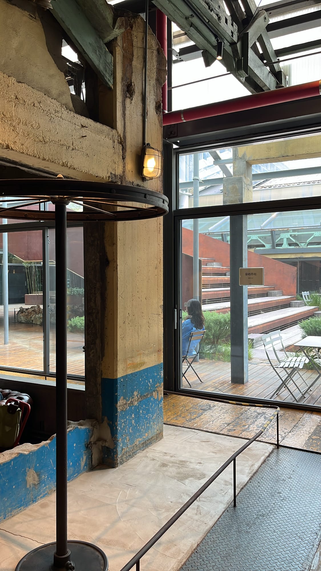 Rustic factory pillar and glass door opening to outdoor courtyard
