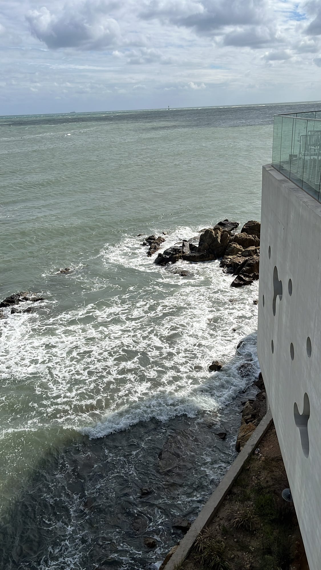 Dramatic ocean waves crashing against coastal rocks viewed from Coralani Busan