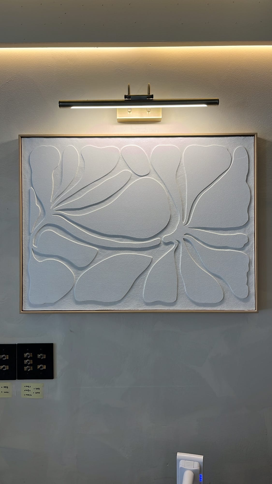 Danicci minimalist white floral textured plaster artwork under warm lamp