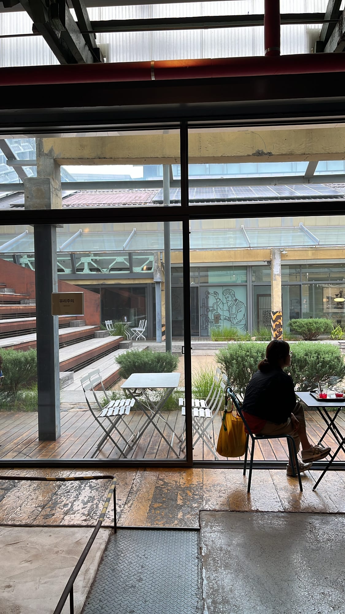 Guest sitting by glass window looking out at F1963 courtyard terrace