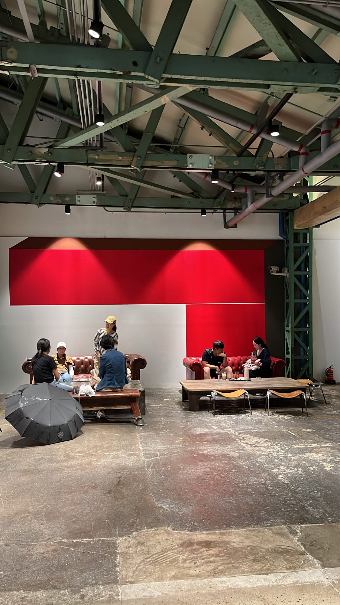 Cozy sofa lounge area set against bold geometric red wall art