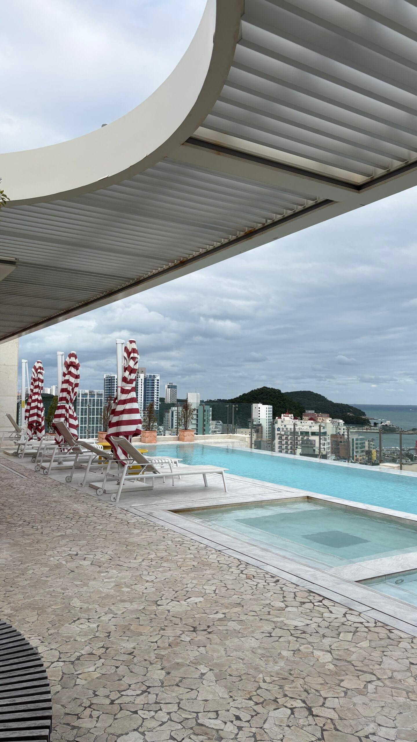 Rooftop swimming pool and striped sun loungers at The Coolest Hotel