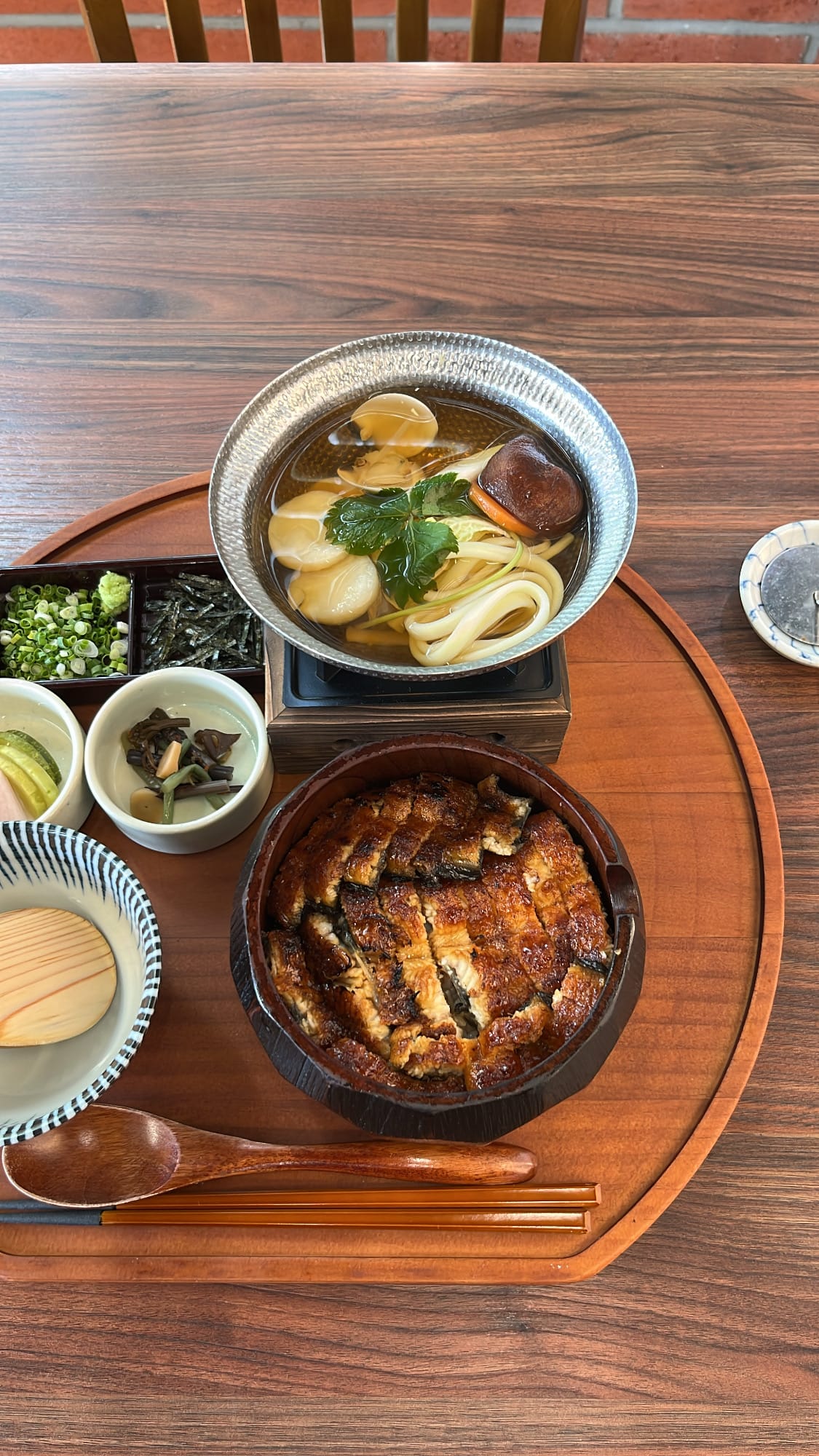 Top-down view of Nagoya hitsumabushi eel bowl, yosenabe soup pot, and condiments at Unaju Busan
