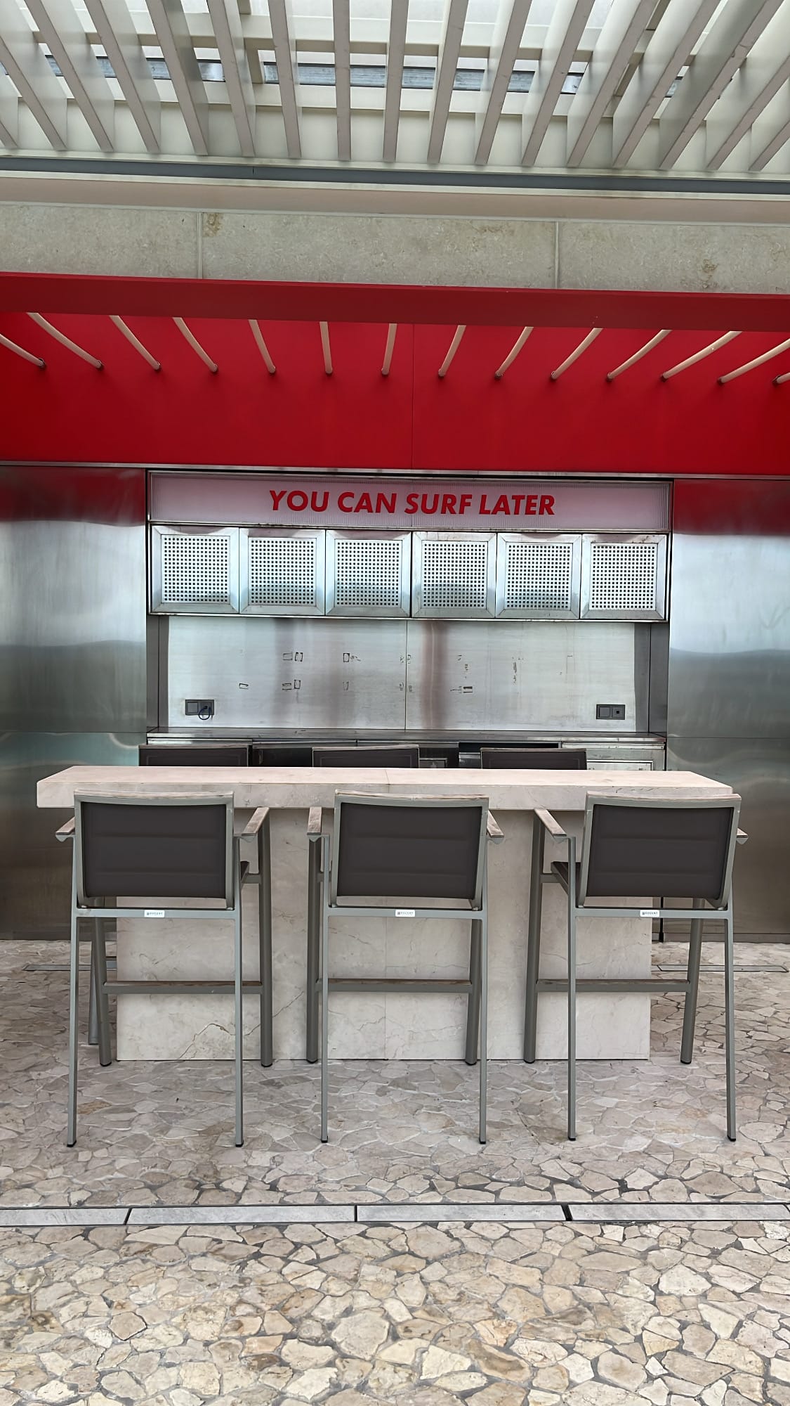 Outdoor bar counter labeled "You Can Surf Later" by the pool