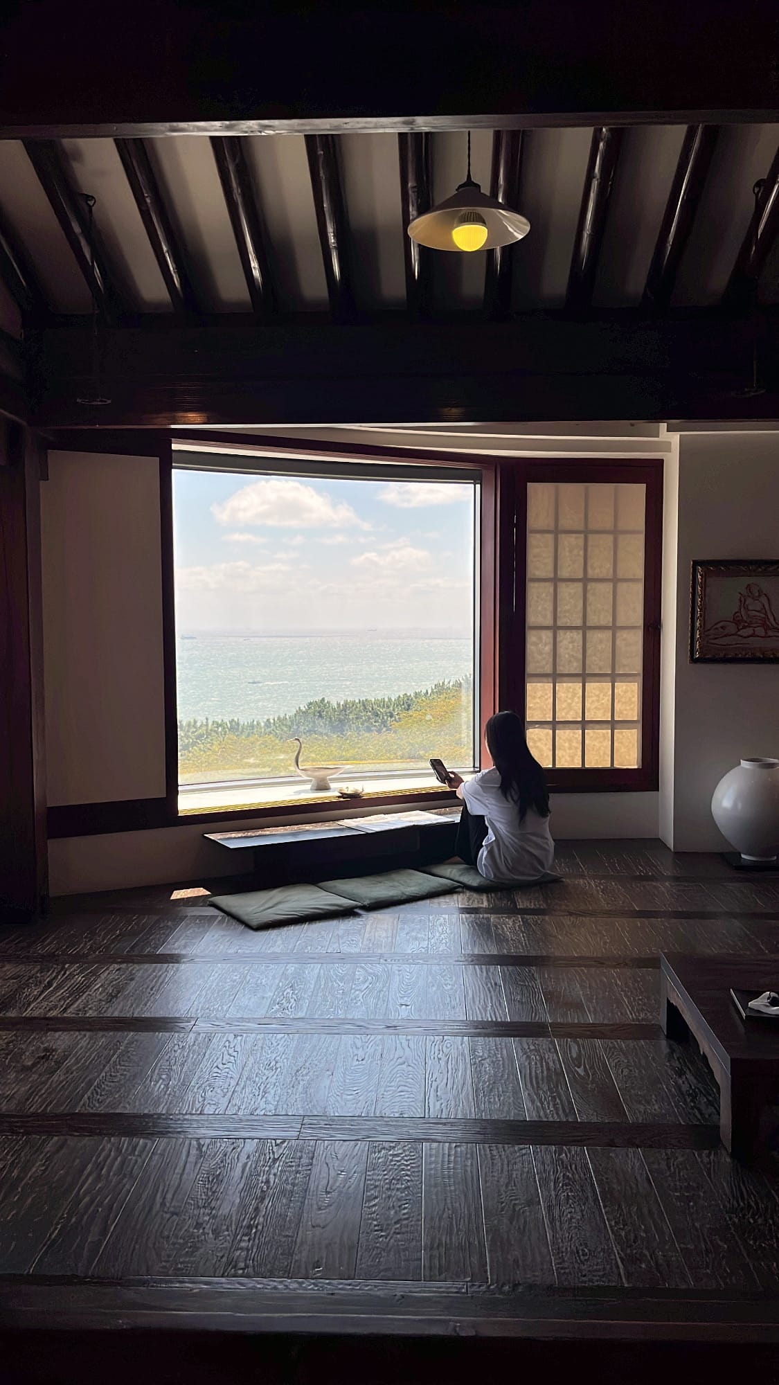Customer sitting by the large ocean-view window enjoying the serene ambiance