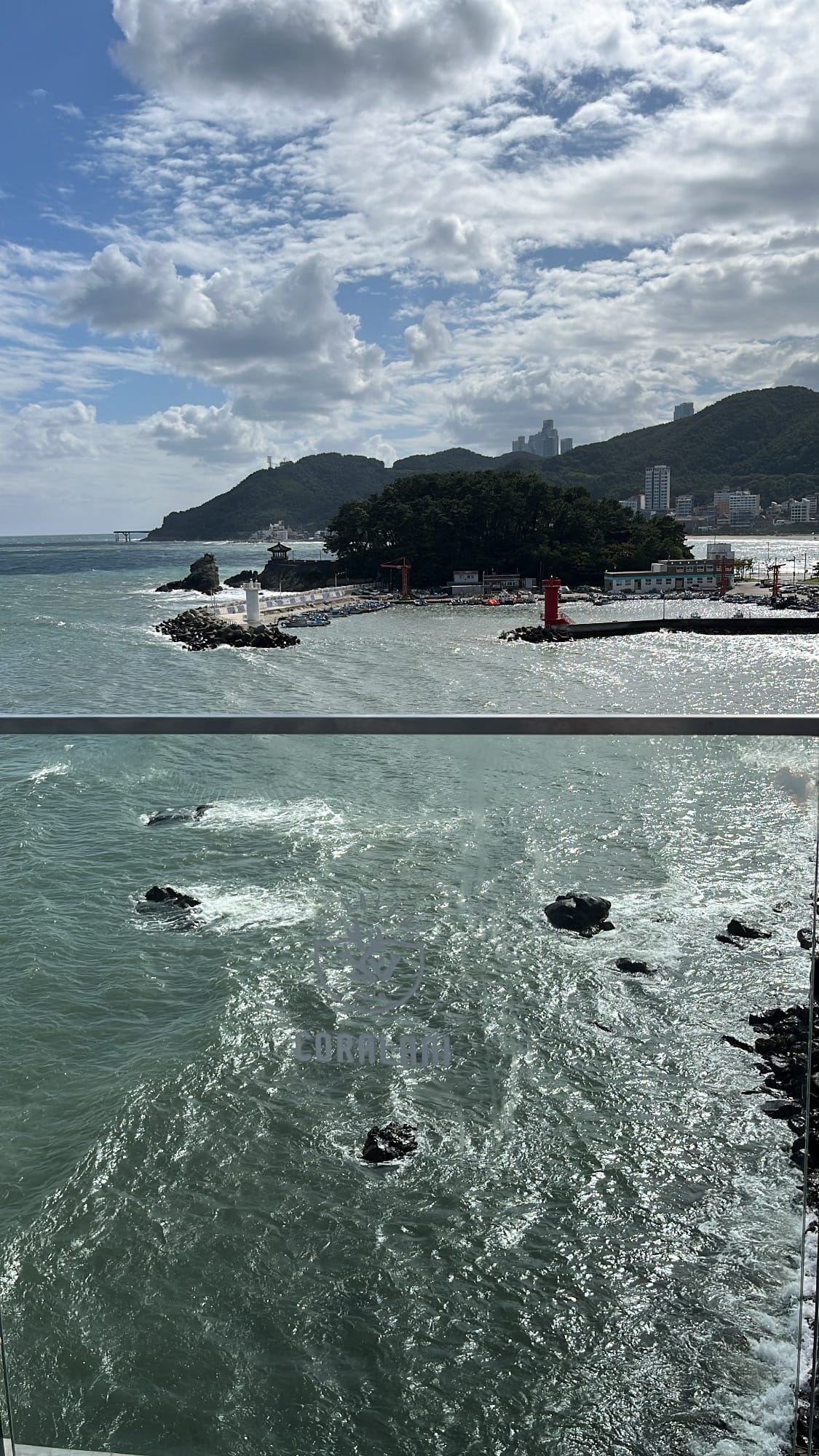Clear elevated panorama of sparkling green ocean waters from Coralani Busan