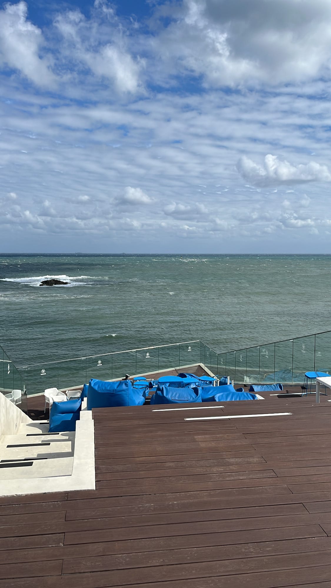 4F rooftop perspective looking down onto the tiered blue beanbag terrace at Coralani Busan