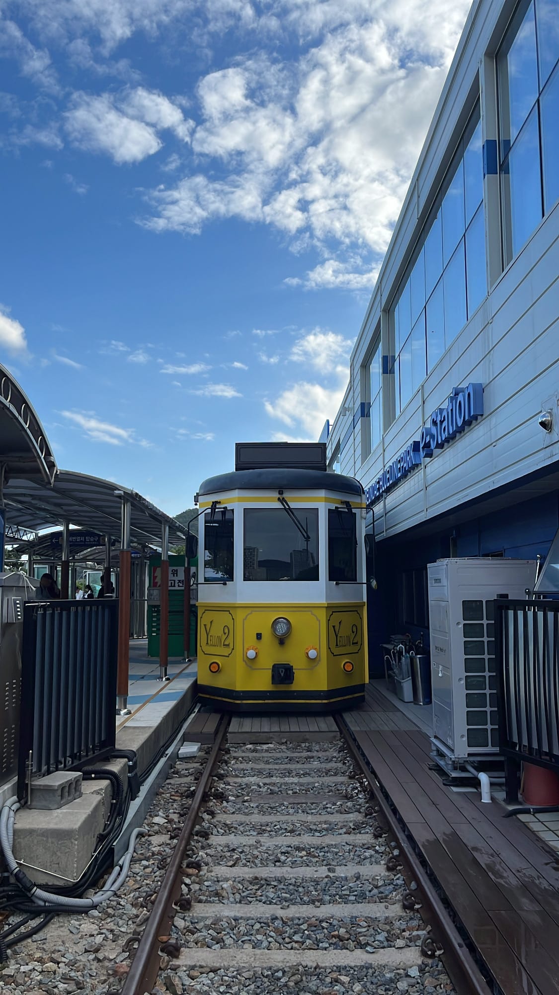 Yellow Blueline Park Beach Train waiting along coastal railway tracks