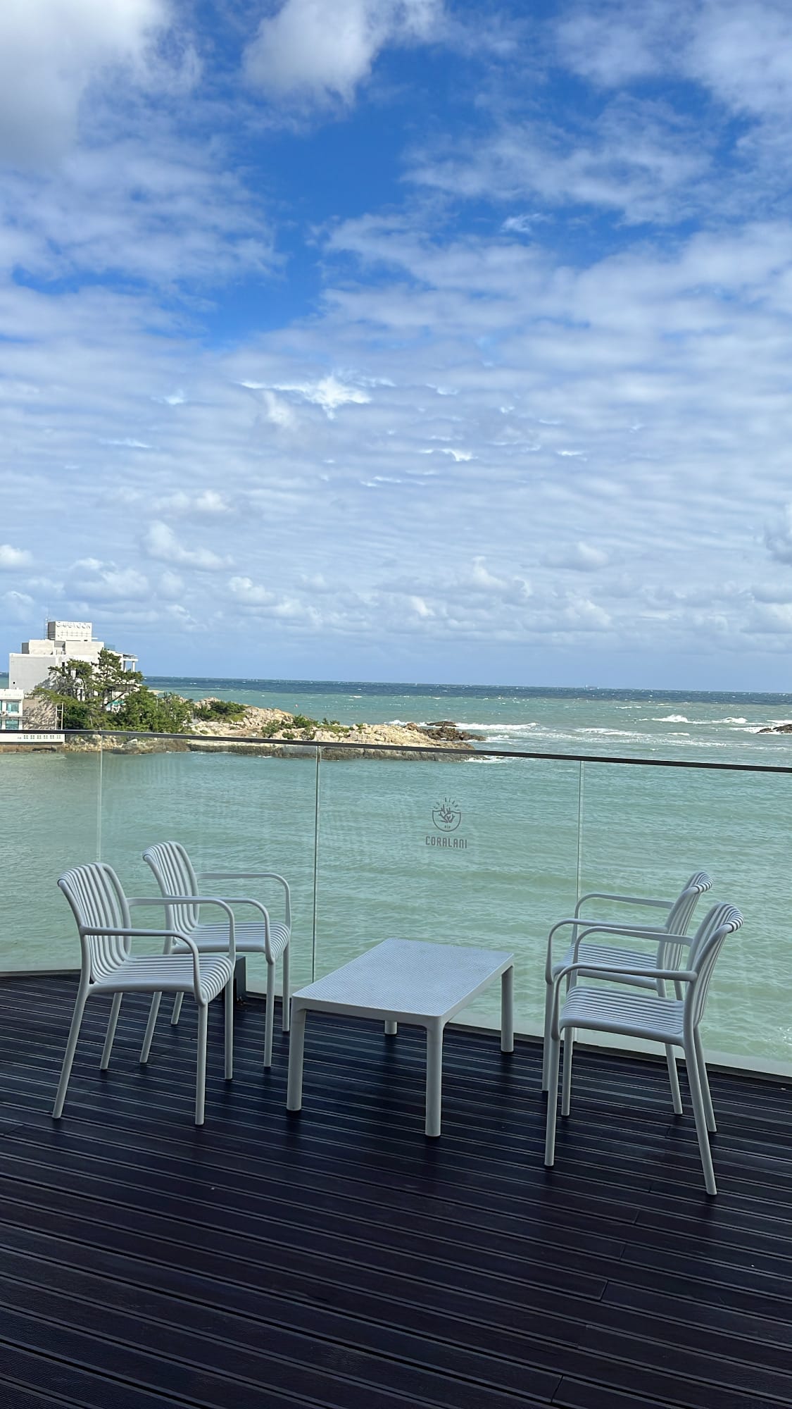 Outdoor patio table and modern chairs set right at the closest edge to the ocean at Coralani Busan