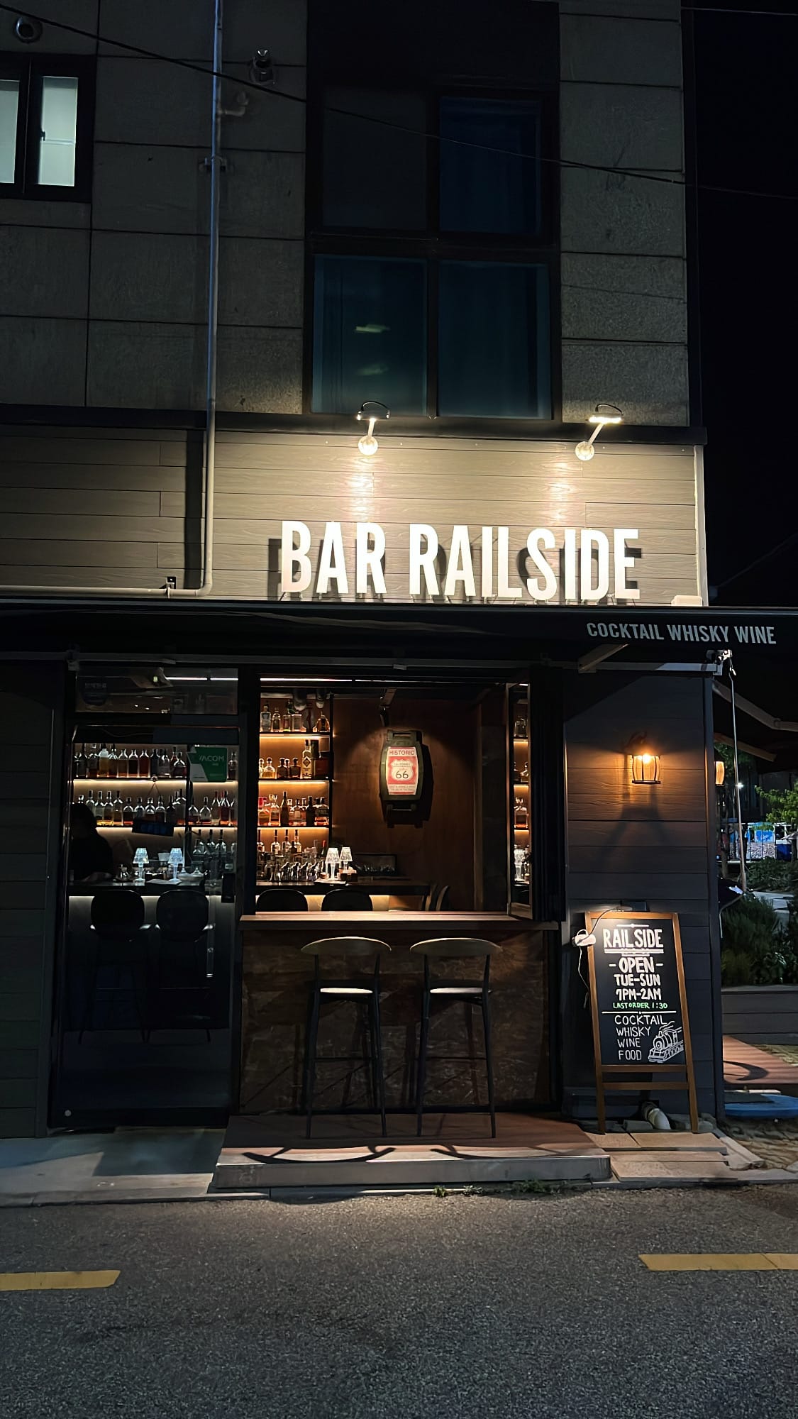 Cozy exterior of Bar Railside lit with warm evening lighting